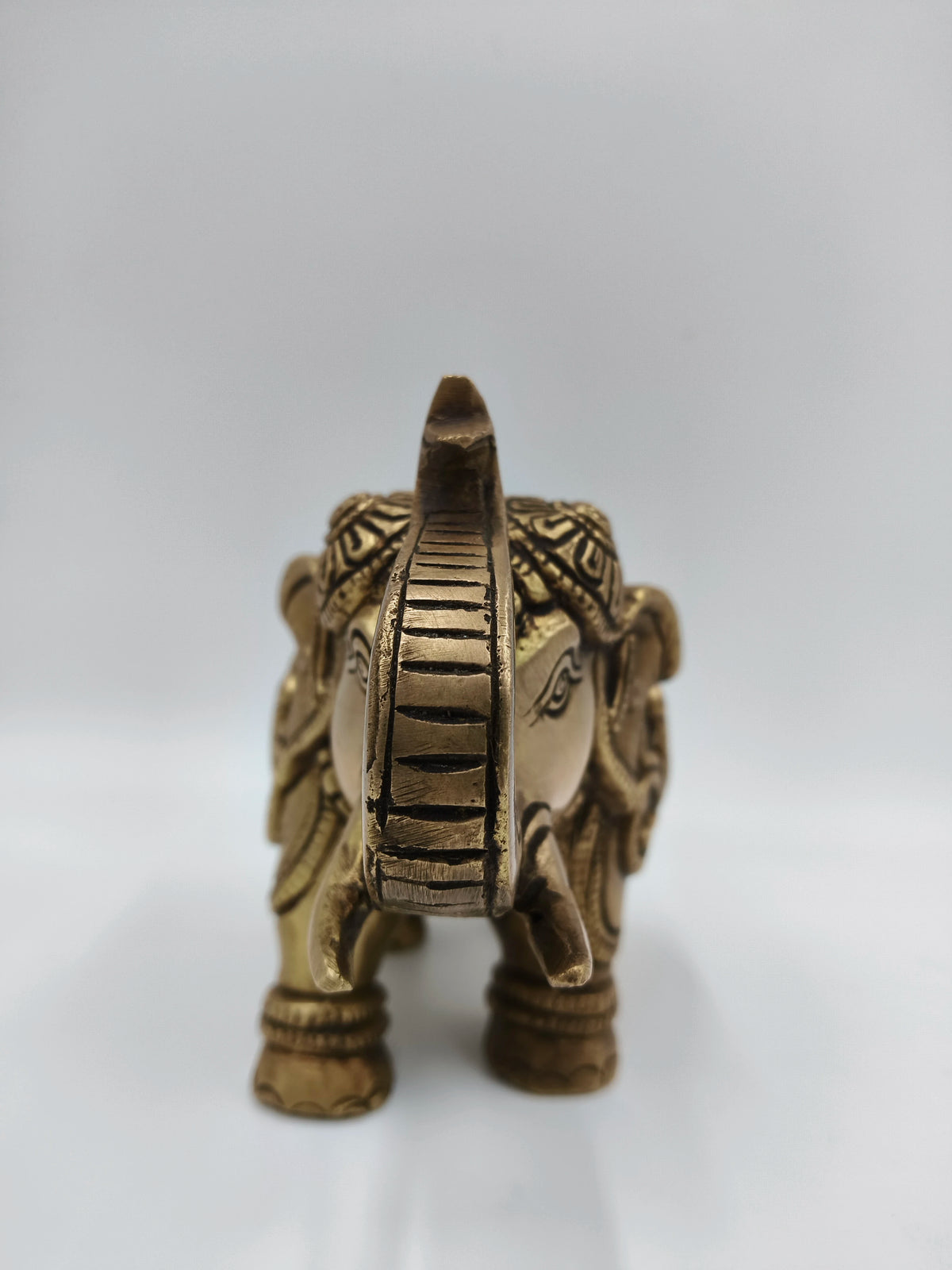 Front view of medium-sized brass elephant figurine with decorative carvings