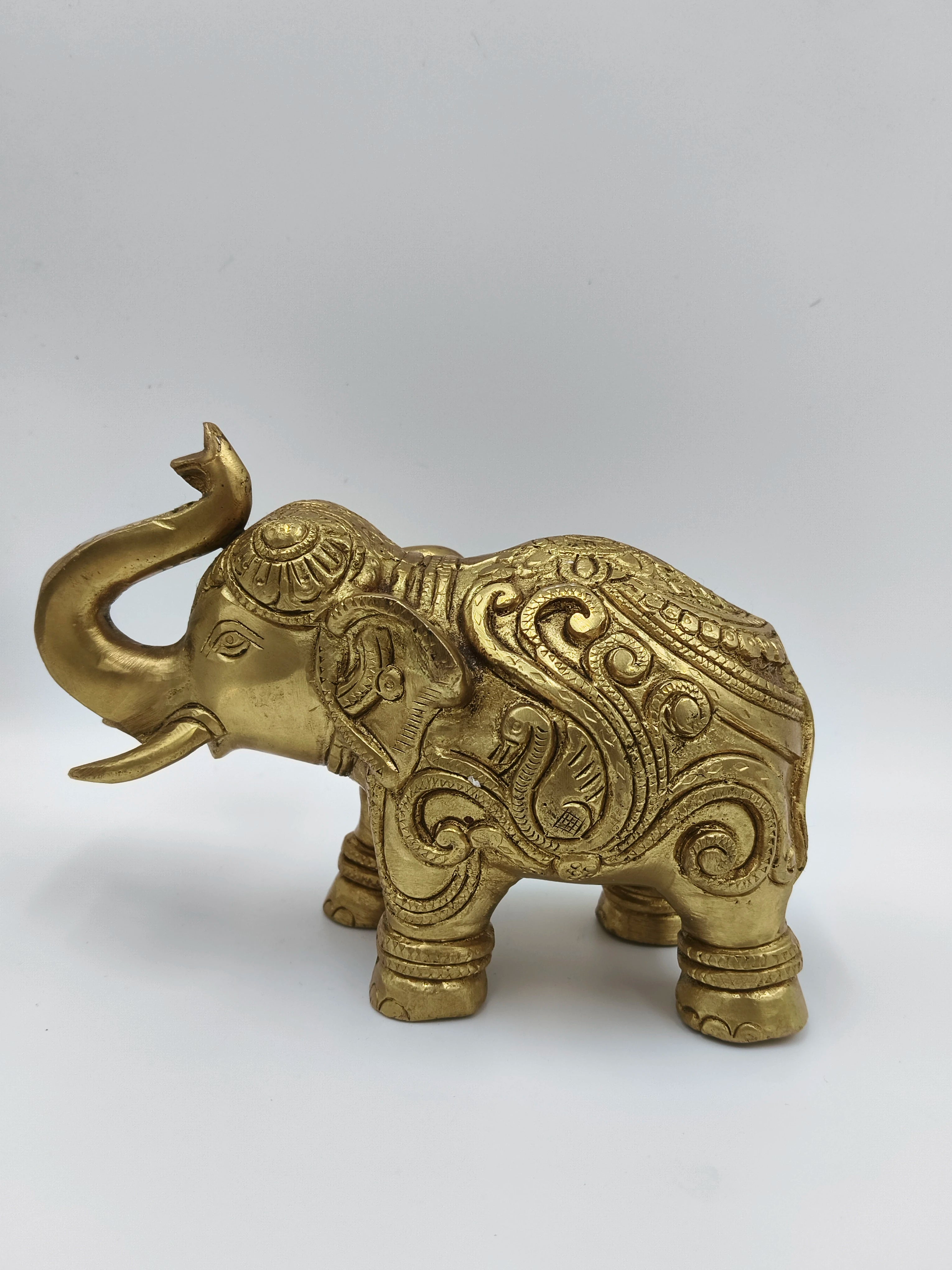 Medium brass elephant figurine with intricate ornate carvings, side view