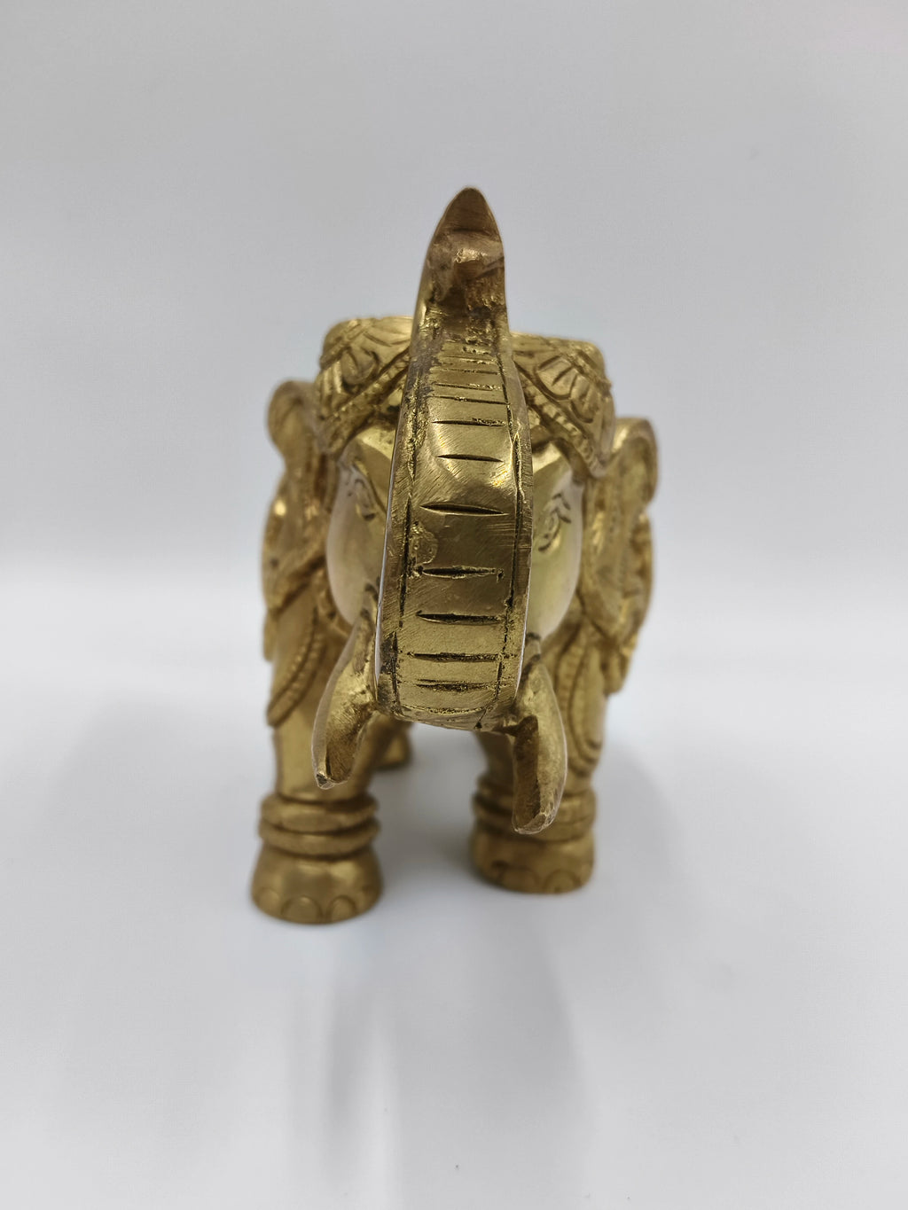 Front view of medium brass elephant figurine with detailed carvings