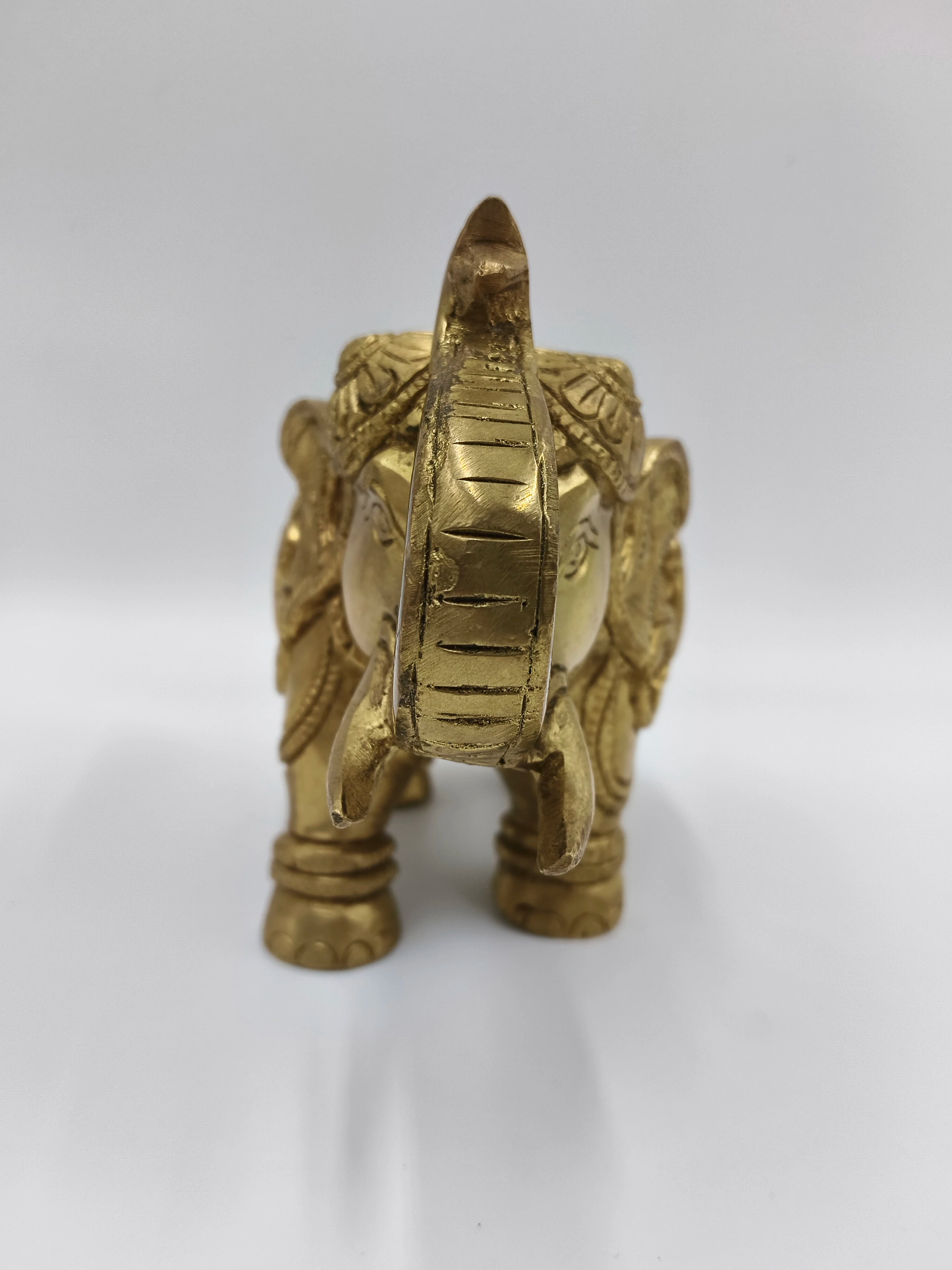 Front view of medium brass elephant figurine with detailed carvings