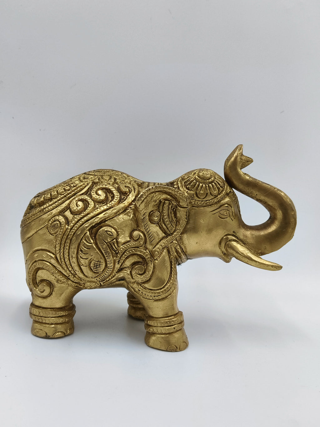 Medium brass elephant figurine with detailed ornate carvings side view