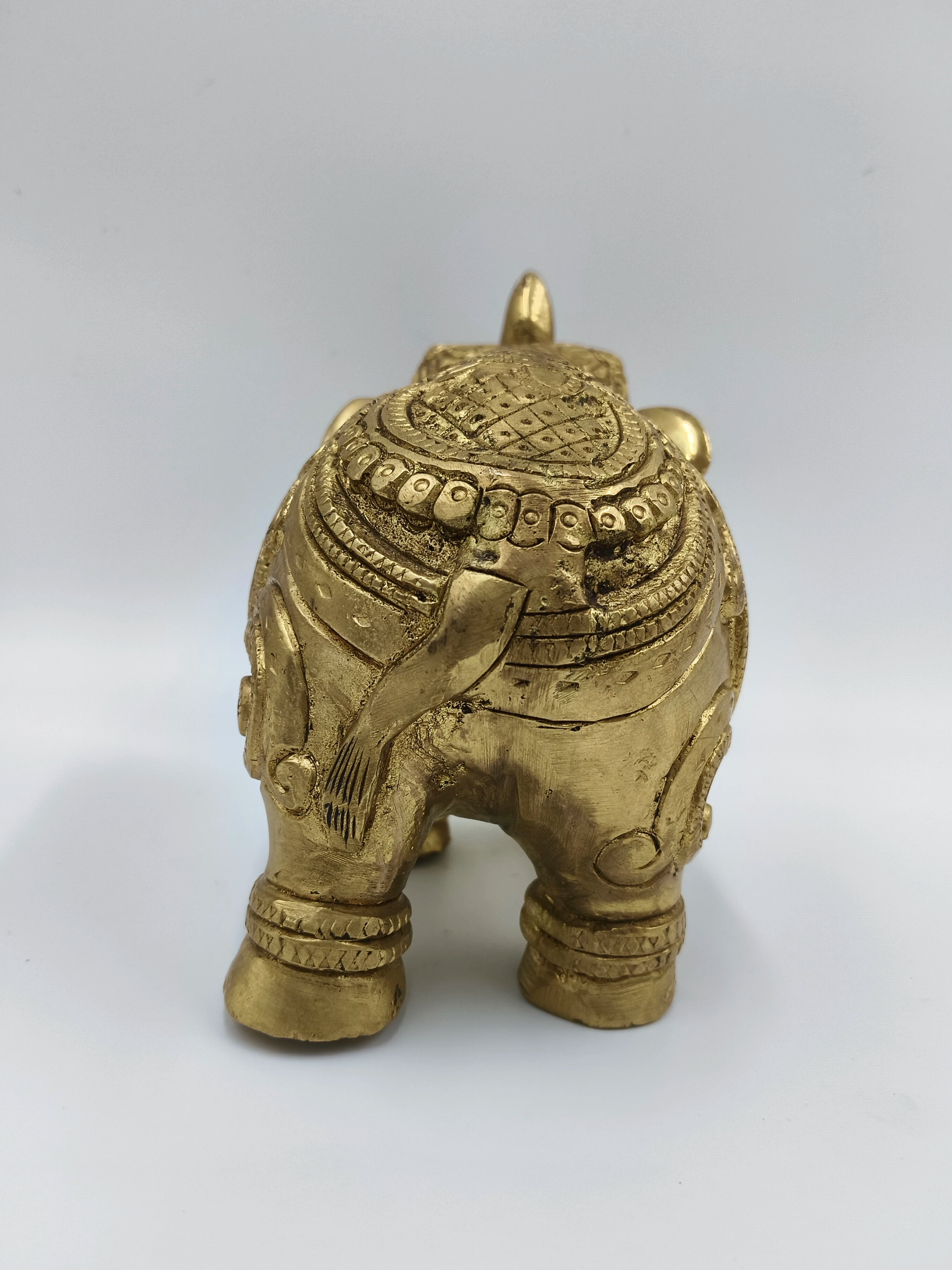 Back view of medium brass elephant figurine with detailed carvings