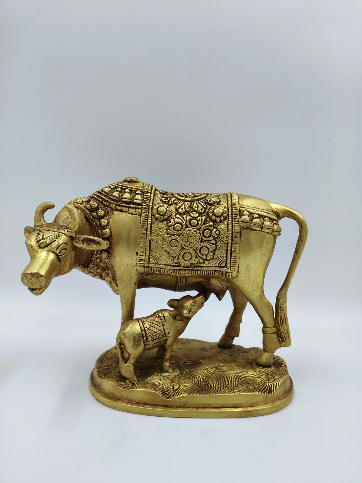 Large brass sculpture of cow and calf with floral patterns and blanket detailing