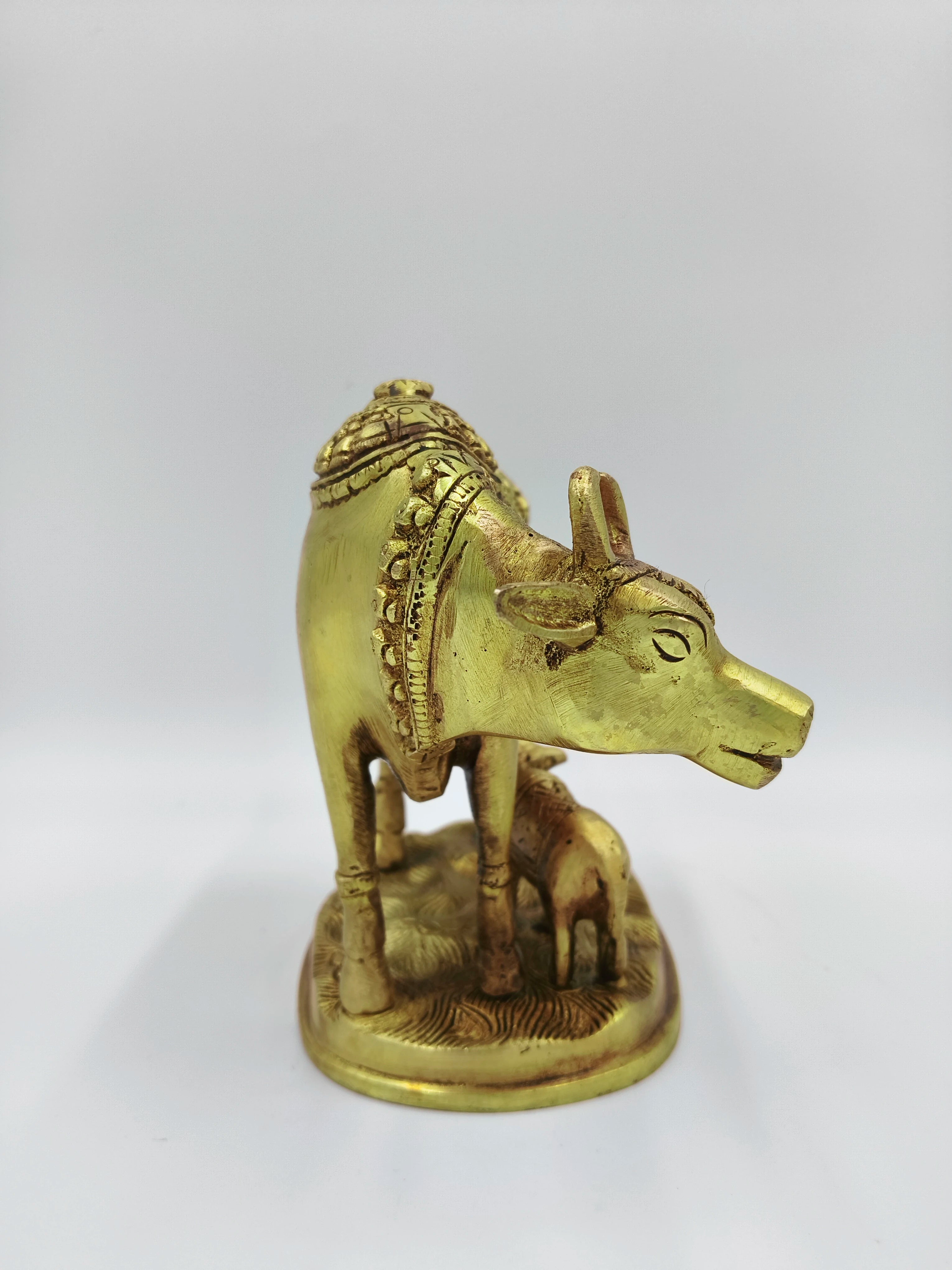 Large brass sculpture of a cow and calf with flower detailing, front view