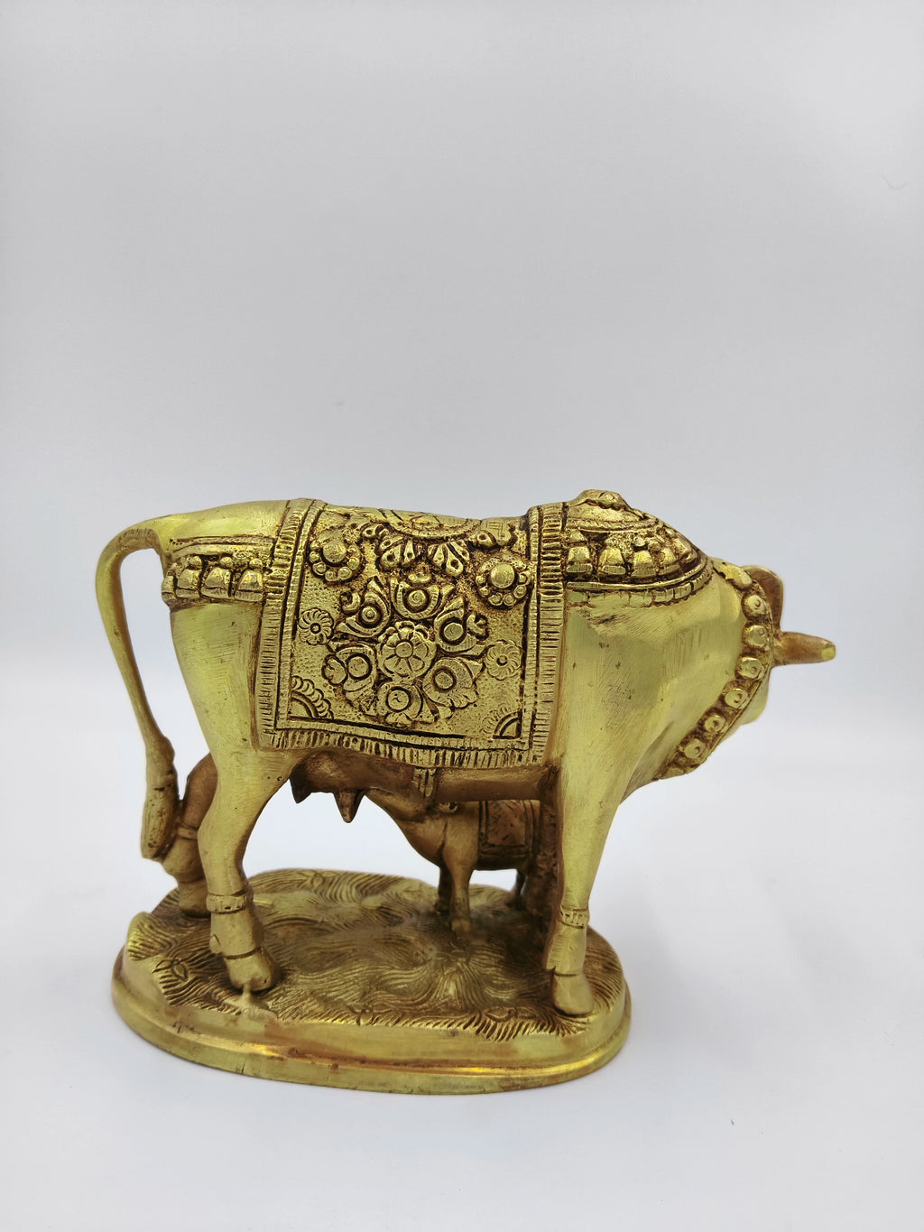 Large brass sculpture of cow and calf with floral patterns side view