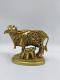 Small brass sculpture of cow and calf with intricate divine figure engravings