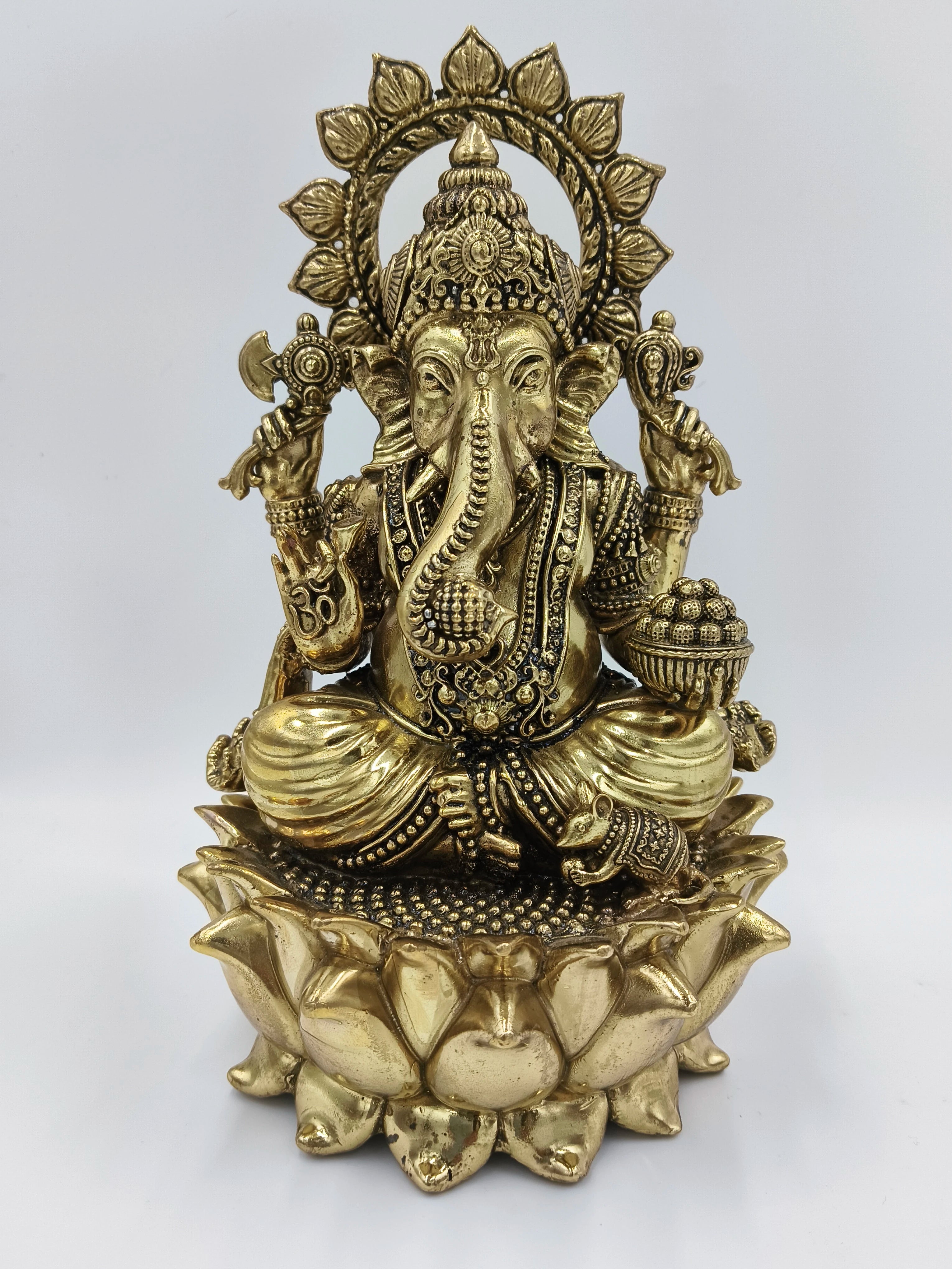Large brass statue of Ganesh seated on detailed lotus flower base