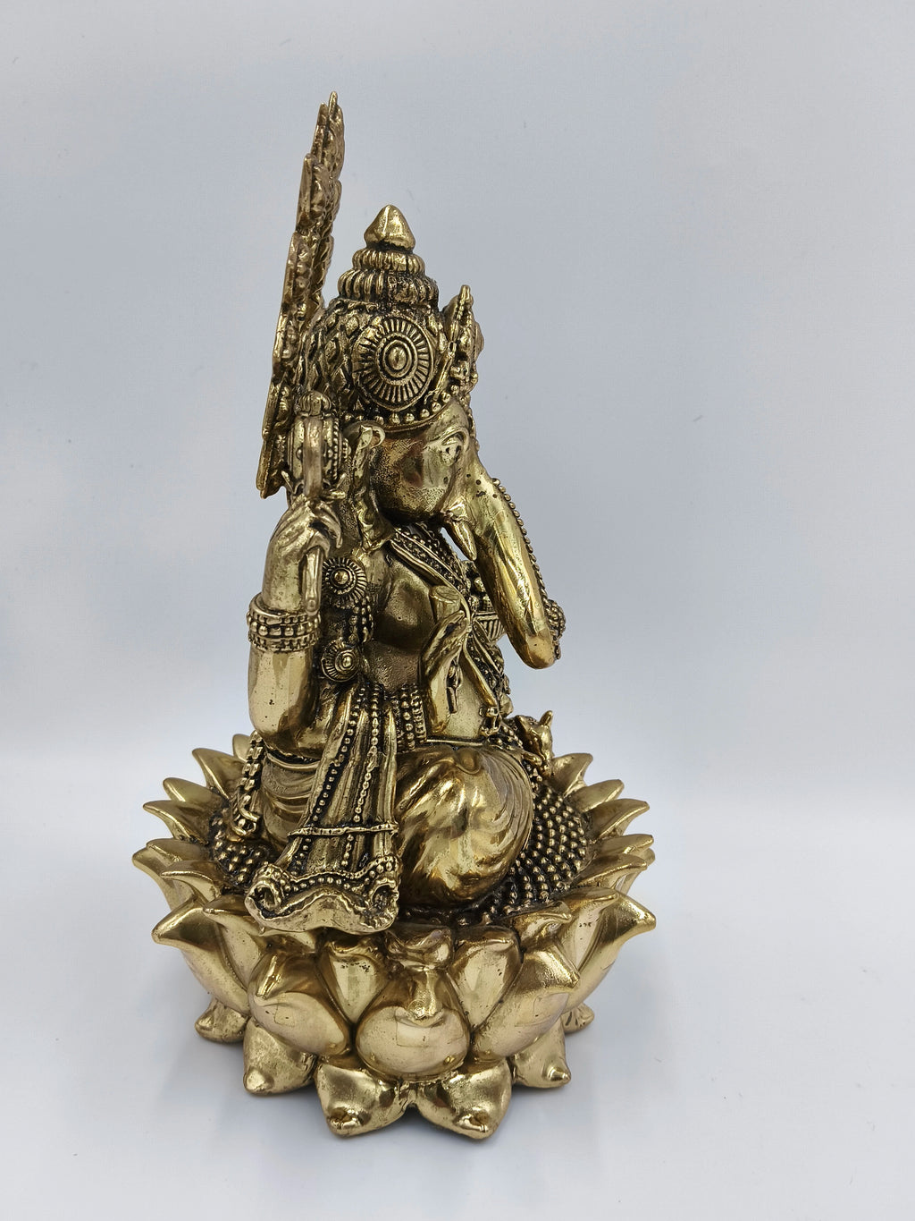 Large brass statue of Ganesh seated on a lotus, side view