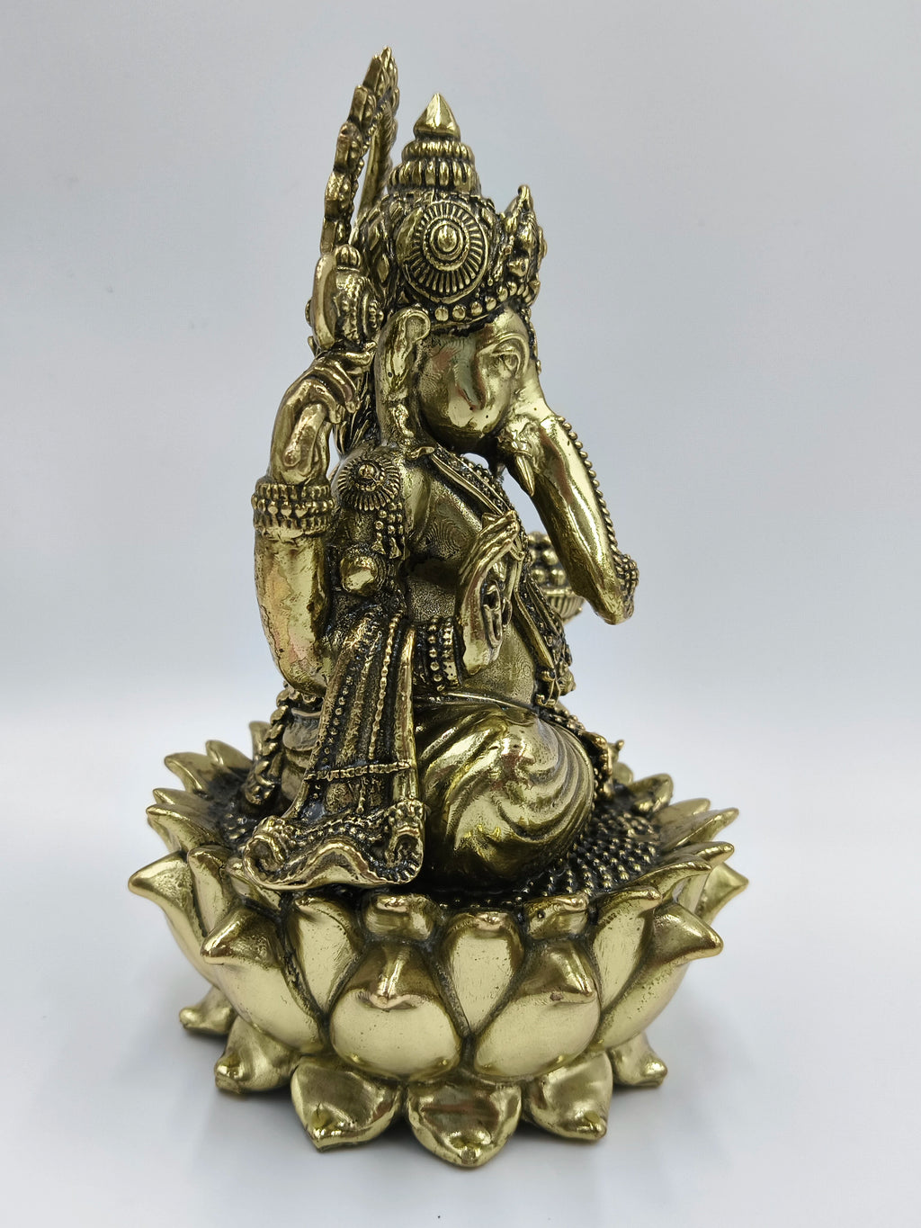 Medium brass statue of Lord Ganesh sitting on a lotus flower base side view