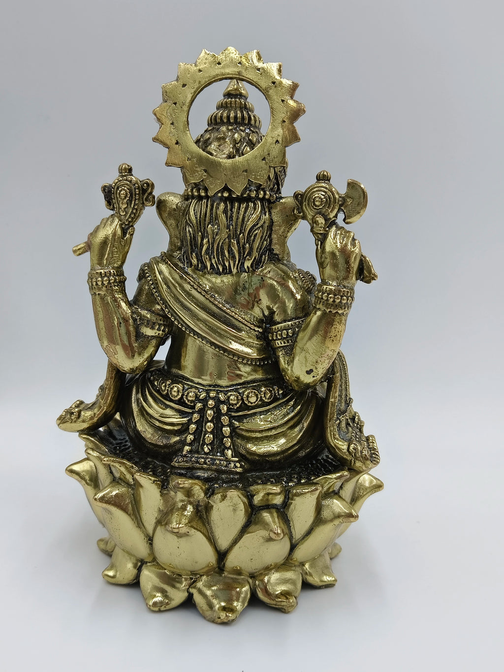 Back view of medium brass Lord Ganesh statue seated on lotus flower