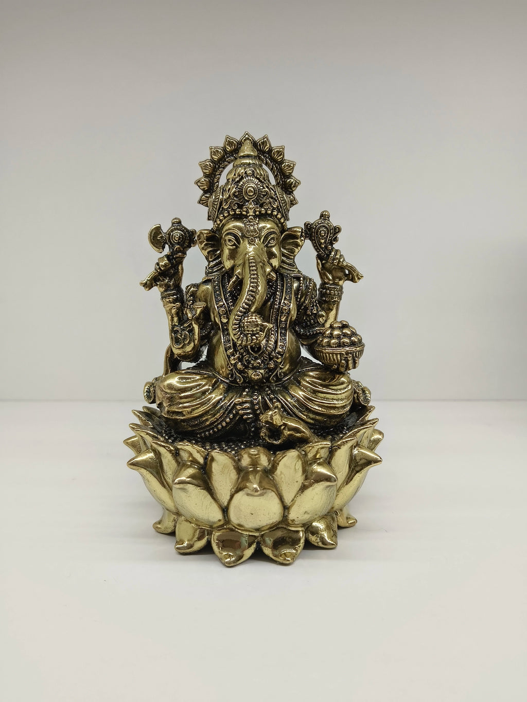 Medium brass statue of Lord Ganesh seated on a lotus flower