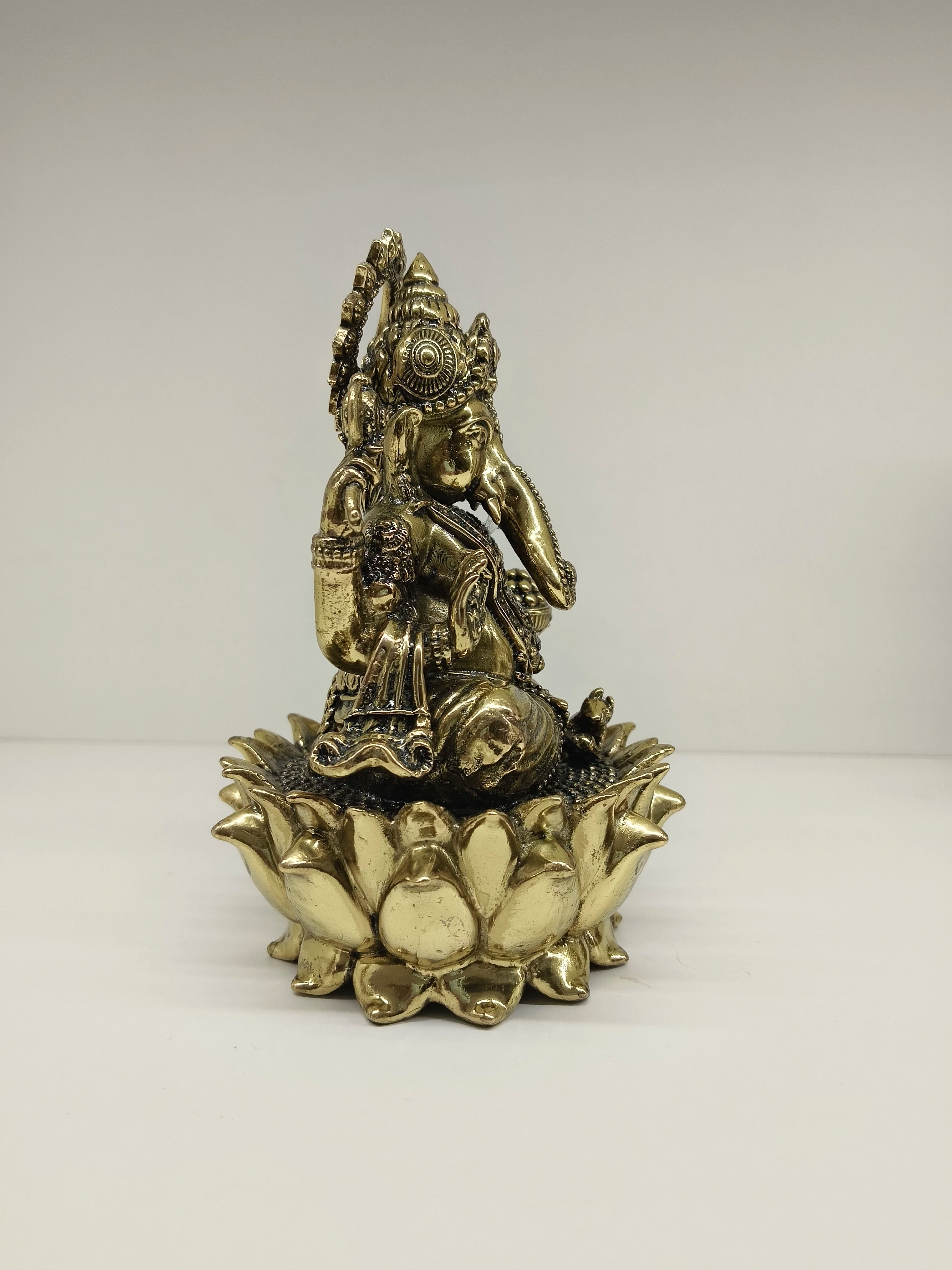 Medium brass statue of Lord Ganesh seated on a lotus flower base, side view