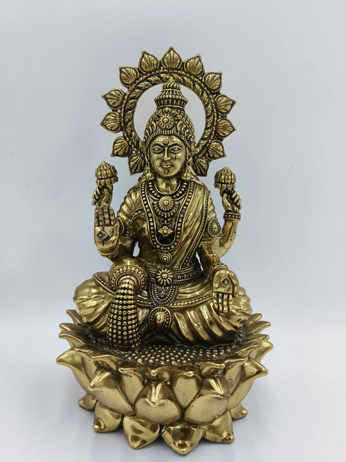 Large brass statue of Goddess Lakshmi seated on a lotus with decorative halo