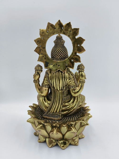 Back view of large brass statue of Goddess Lakshmi seated on a lotus flower