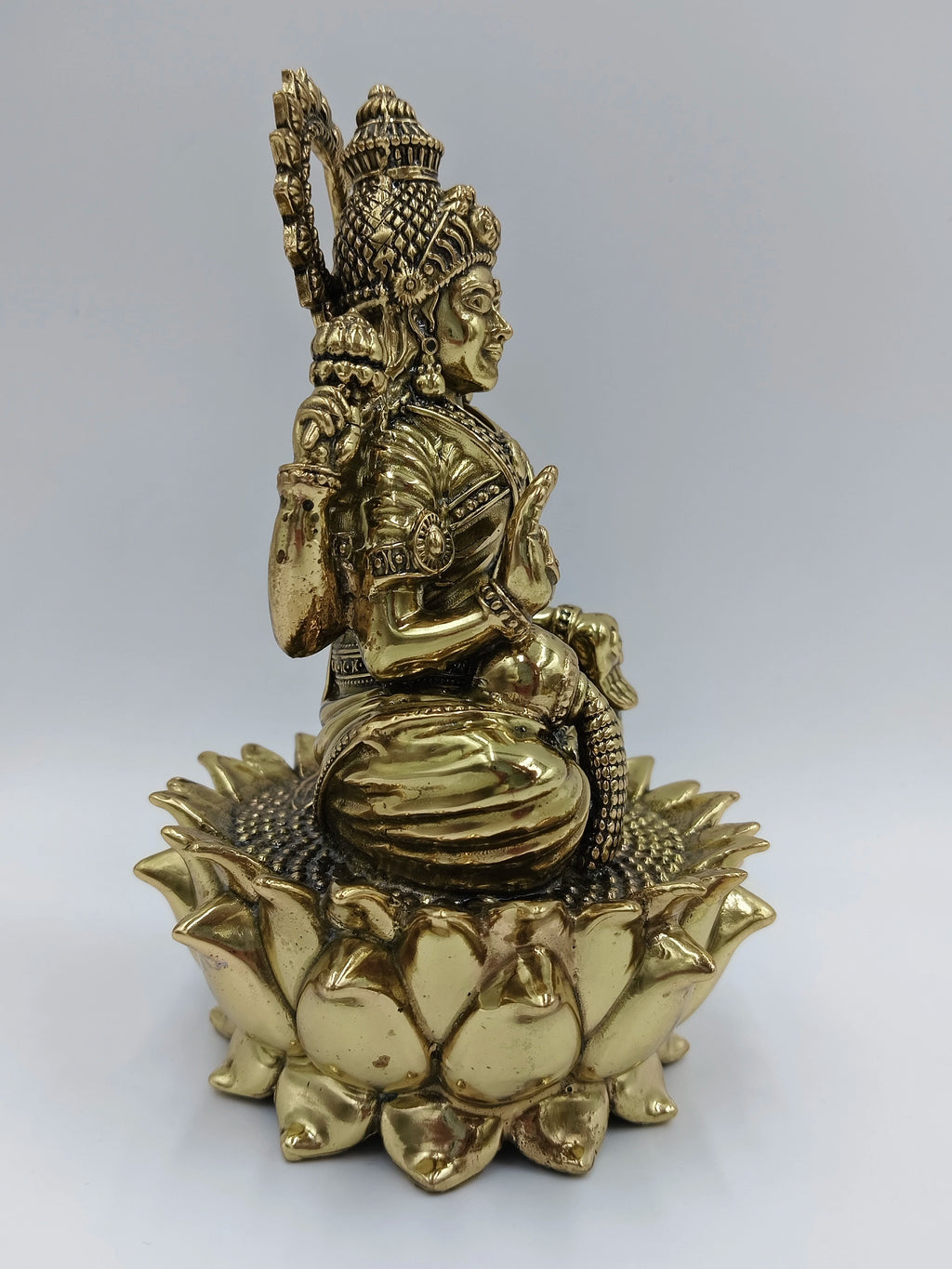 Brass statue of Goddess Lakshmi seated on a lotus, side view
