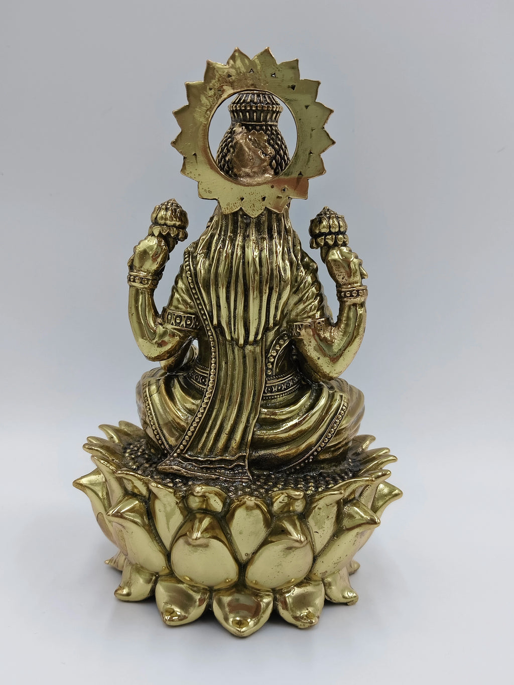 Back view of medium brass statue of Goddess Lakshmi seated on lotus flower