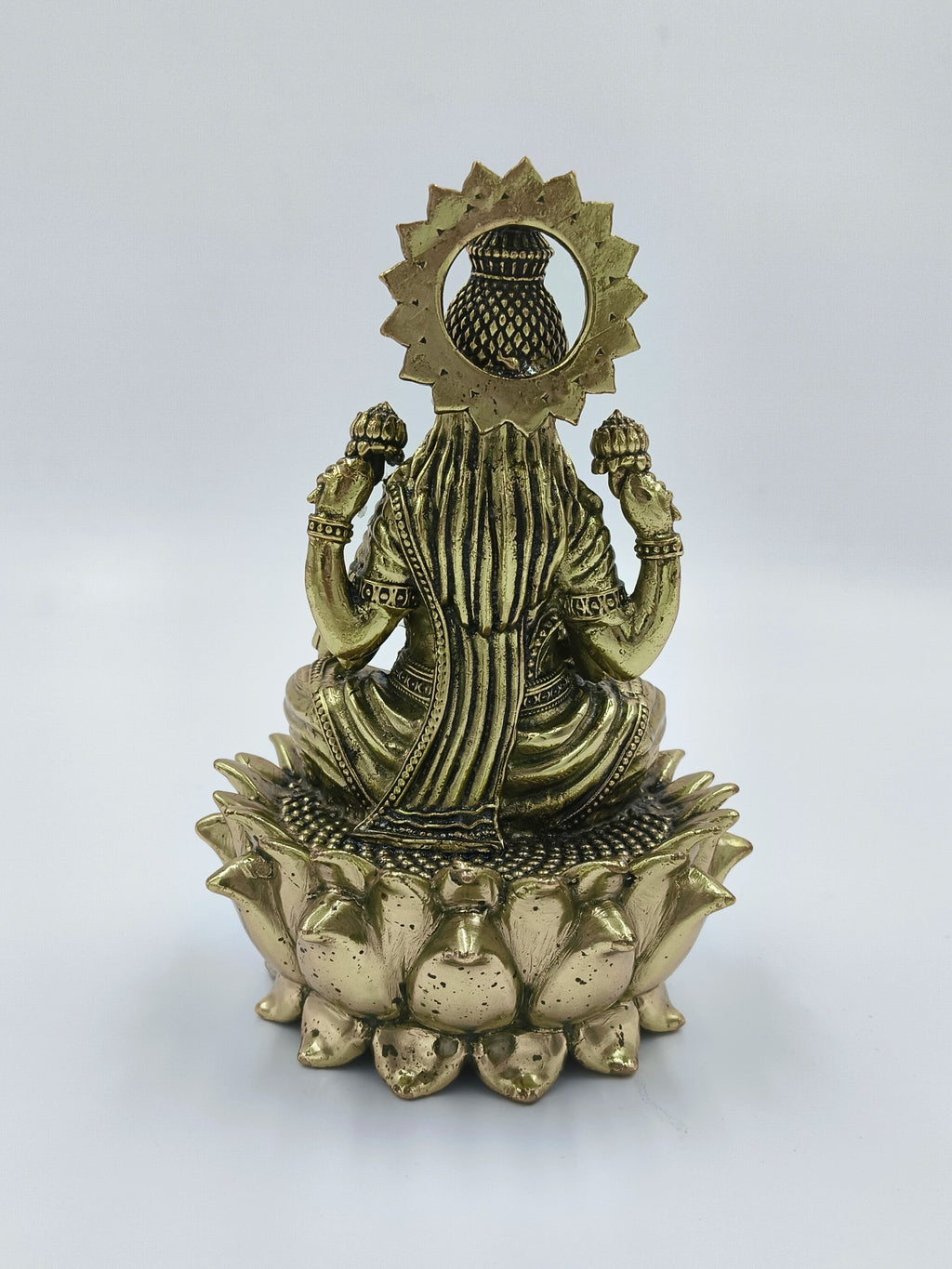 Rear view of brass sculpture of Goddess Lakshmi seated on lotus