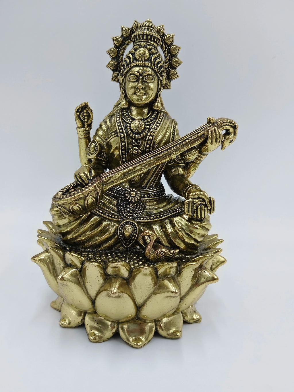 Medium brass statue of Goddess Saraswathi seated on a lotus playing veena