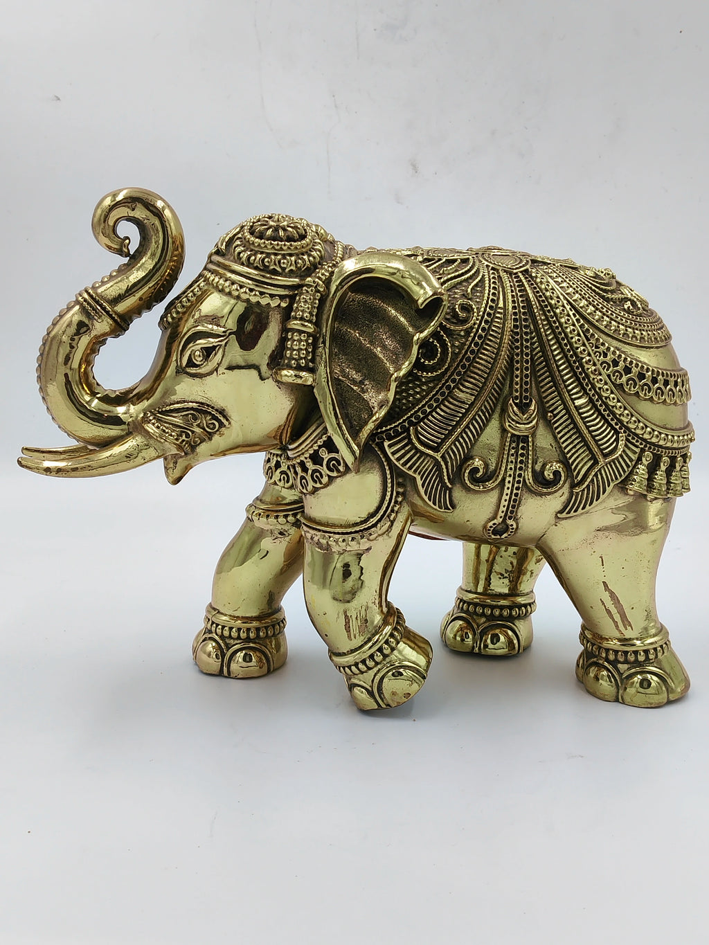 Large brass elephant sculpture with detailed ornamental patterns
