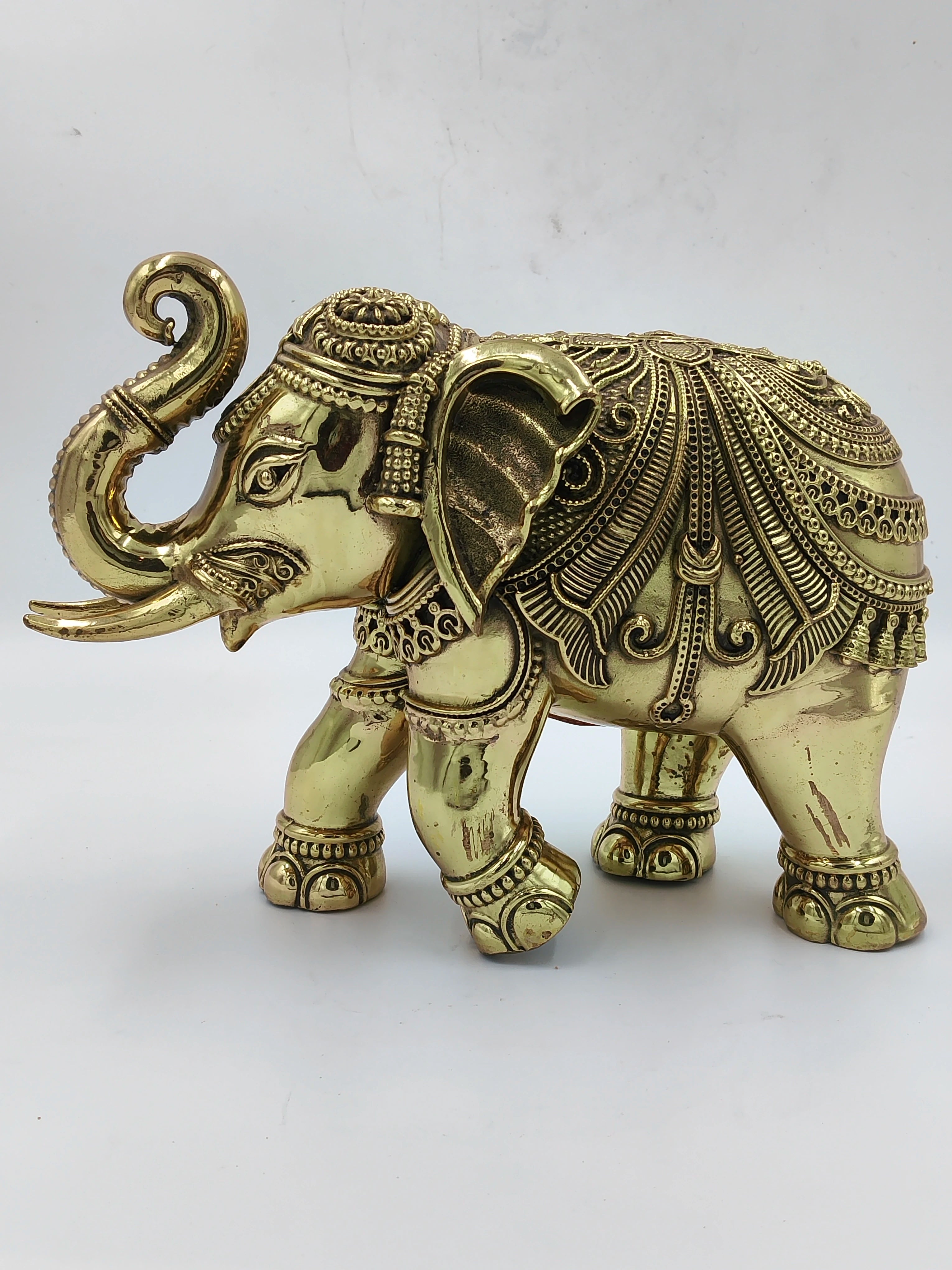 Large brass elephant sculpture with detailed ornamental patterns