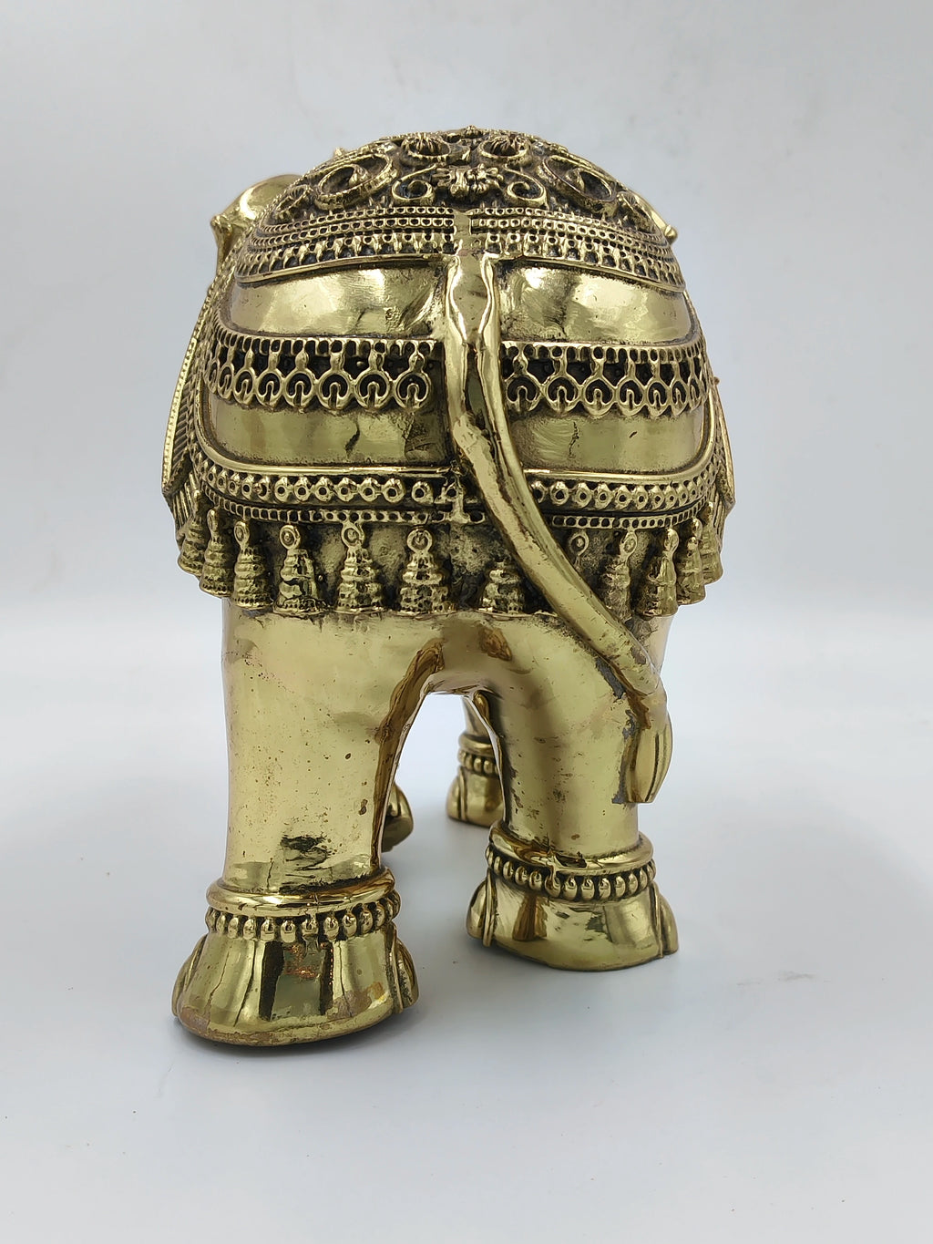Large brass elephant sculpture with decorative ornaments, rear view