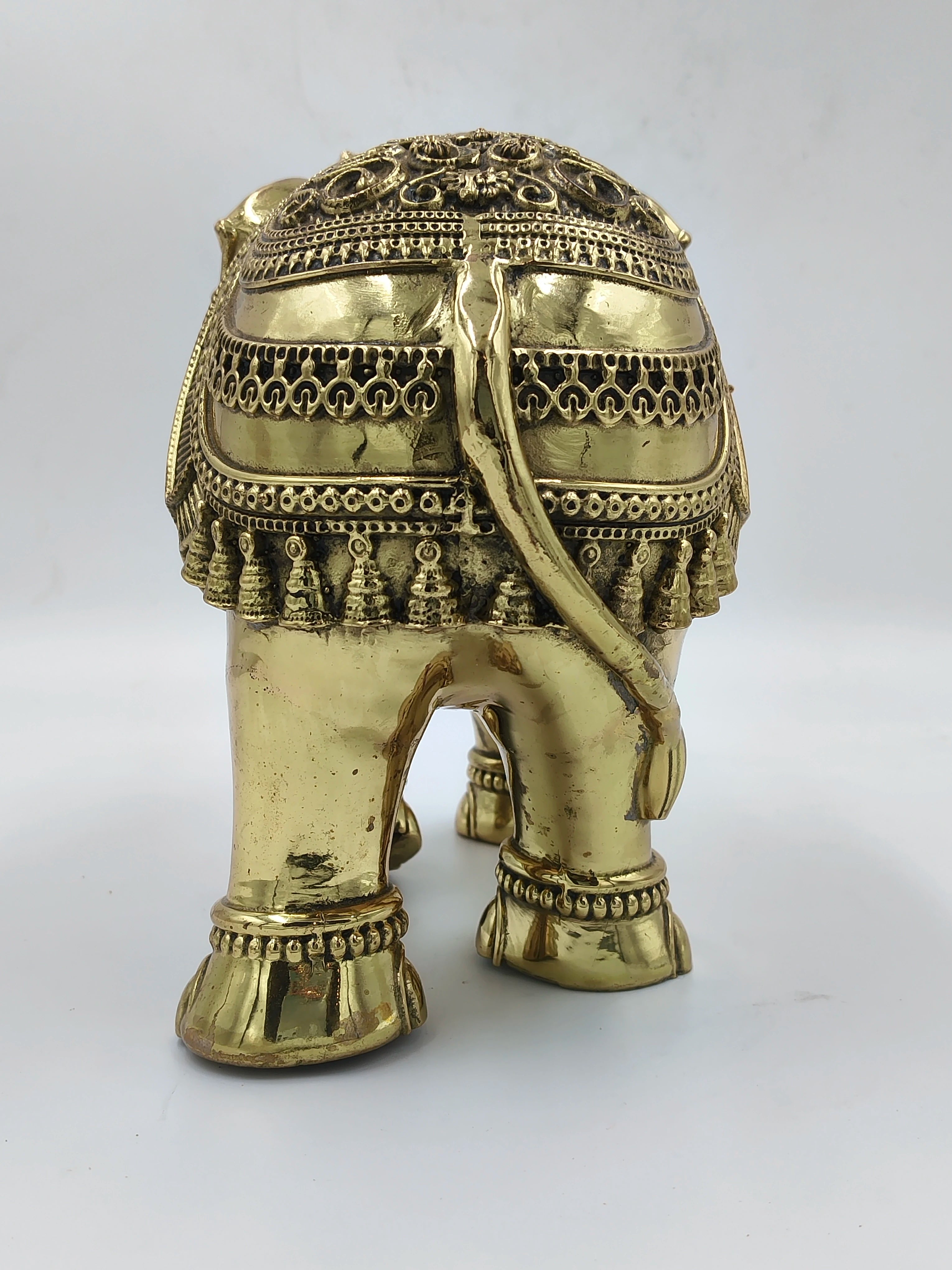 Large brass elephant sculpture with decorative ornaments, rear view