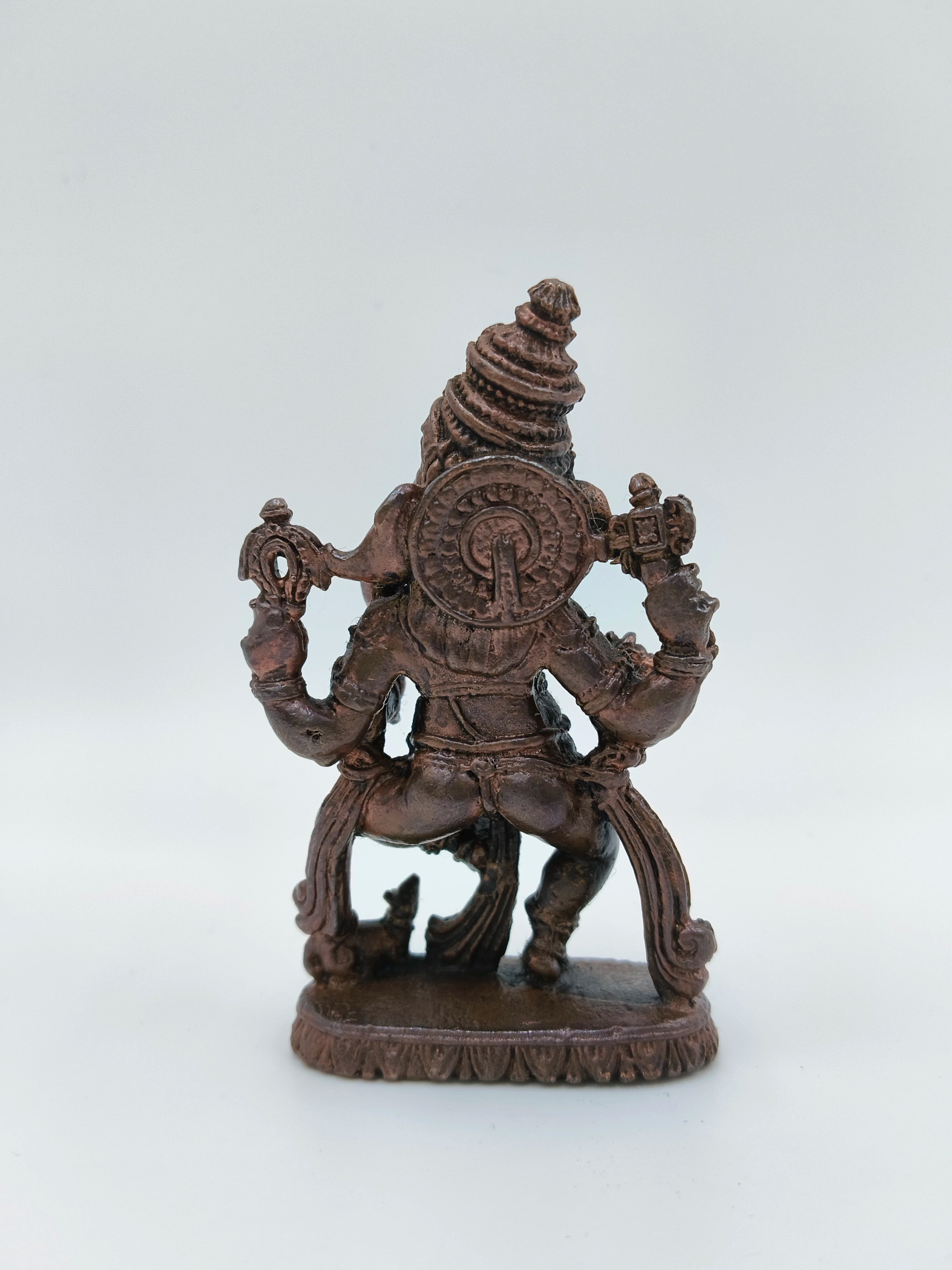 Back view of small brass dancing Ganesh statue with intricate detailing