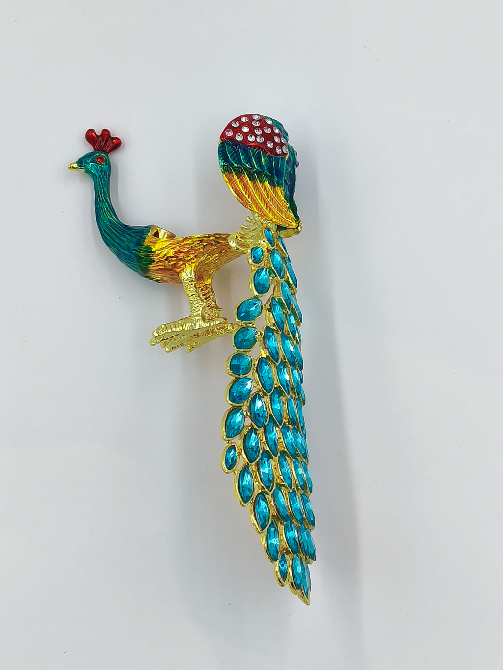 Small brass peacock figurine with copper enamel and blue gem tail detail