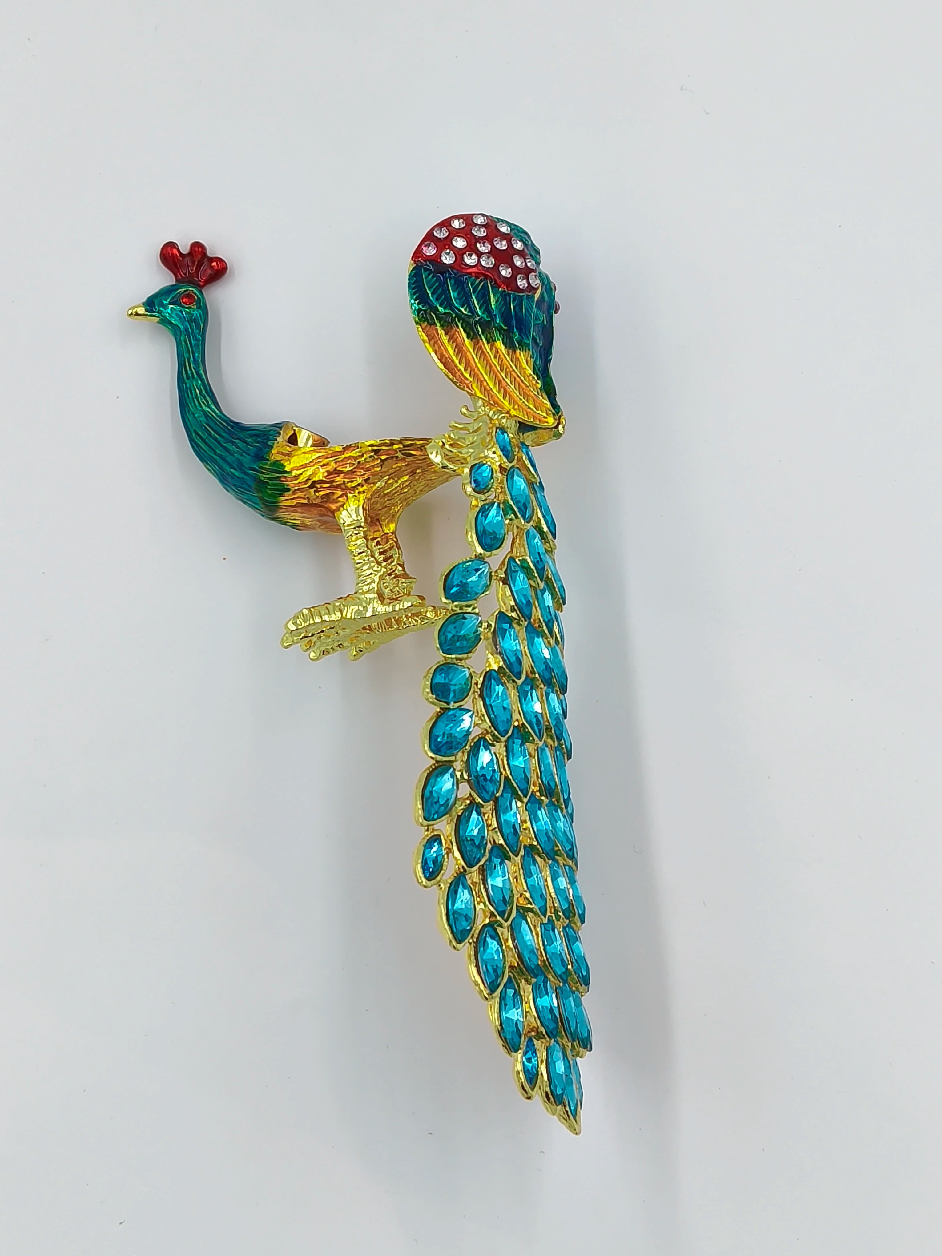 Small brass peacock figurine with copper enamel and blue gem tail detail