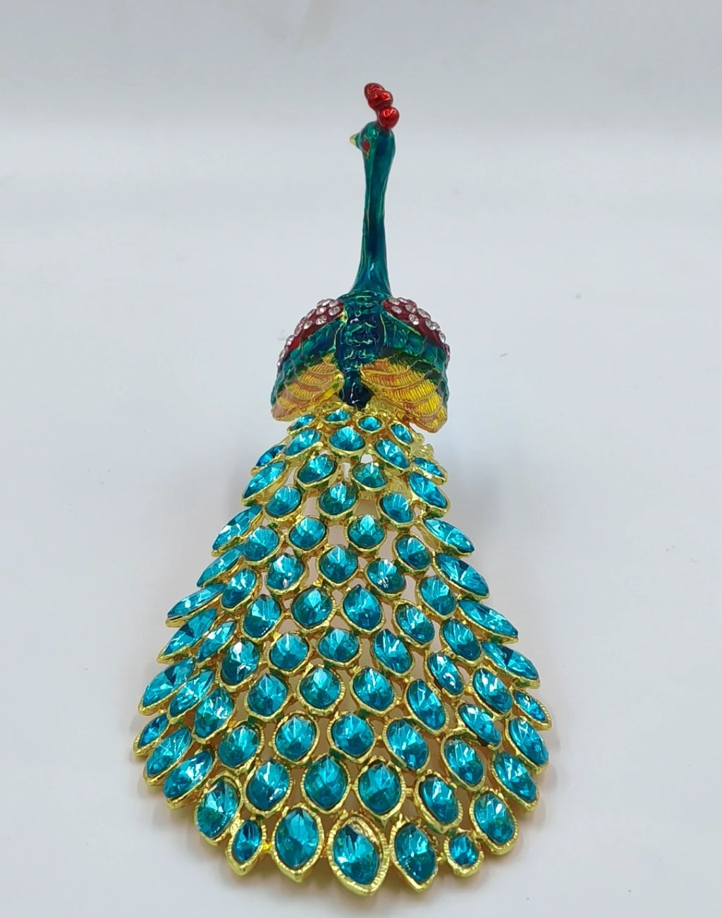 Small brass peacock figurine with copper enamel and blue gemstone tail detail