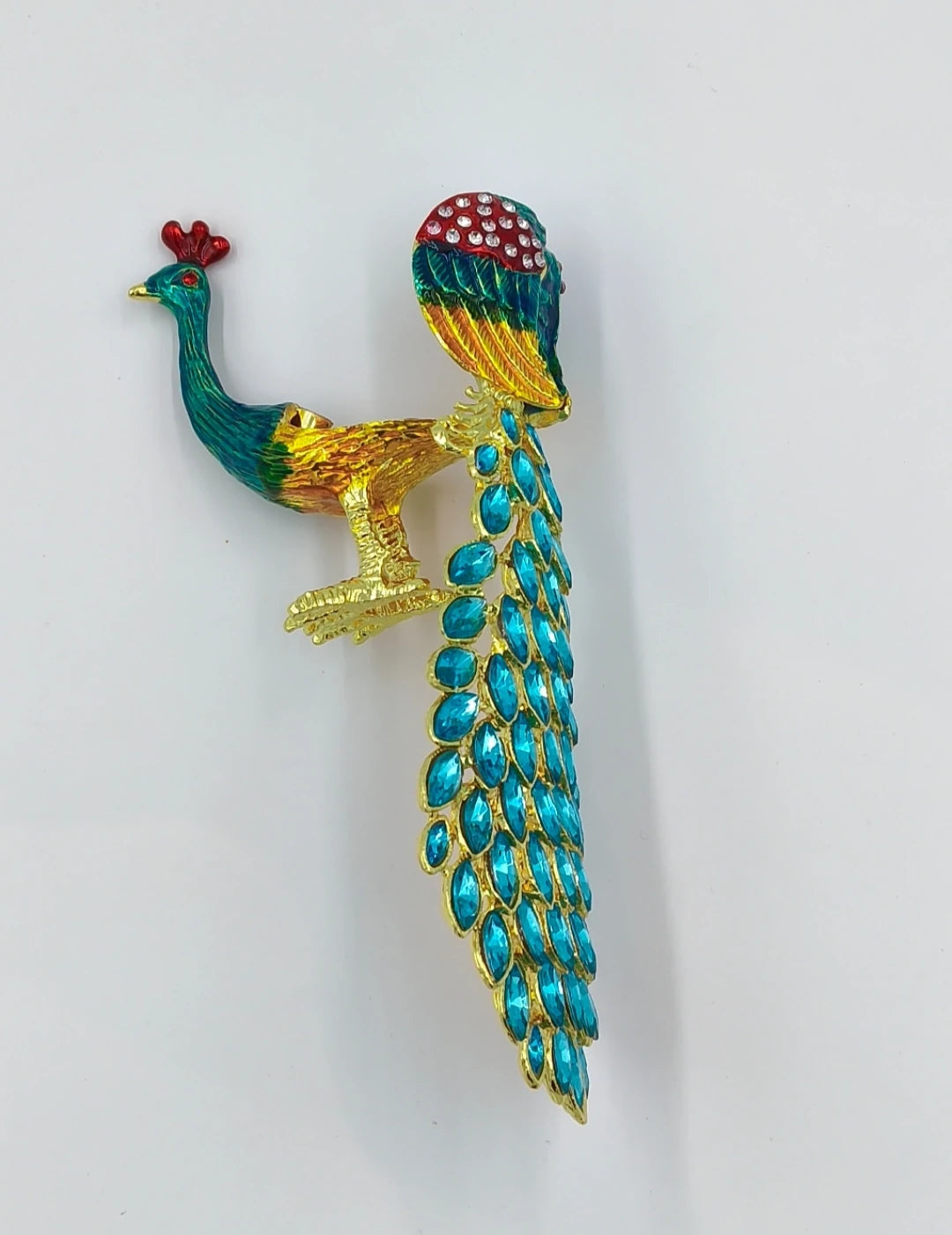 Small brass peacock figurine with copper enamel and blue jewel-like tail