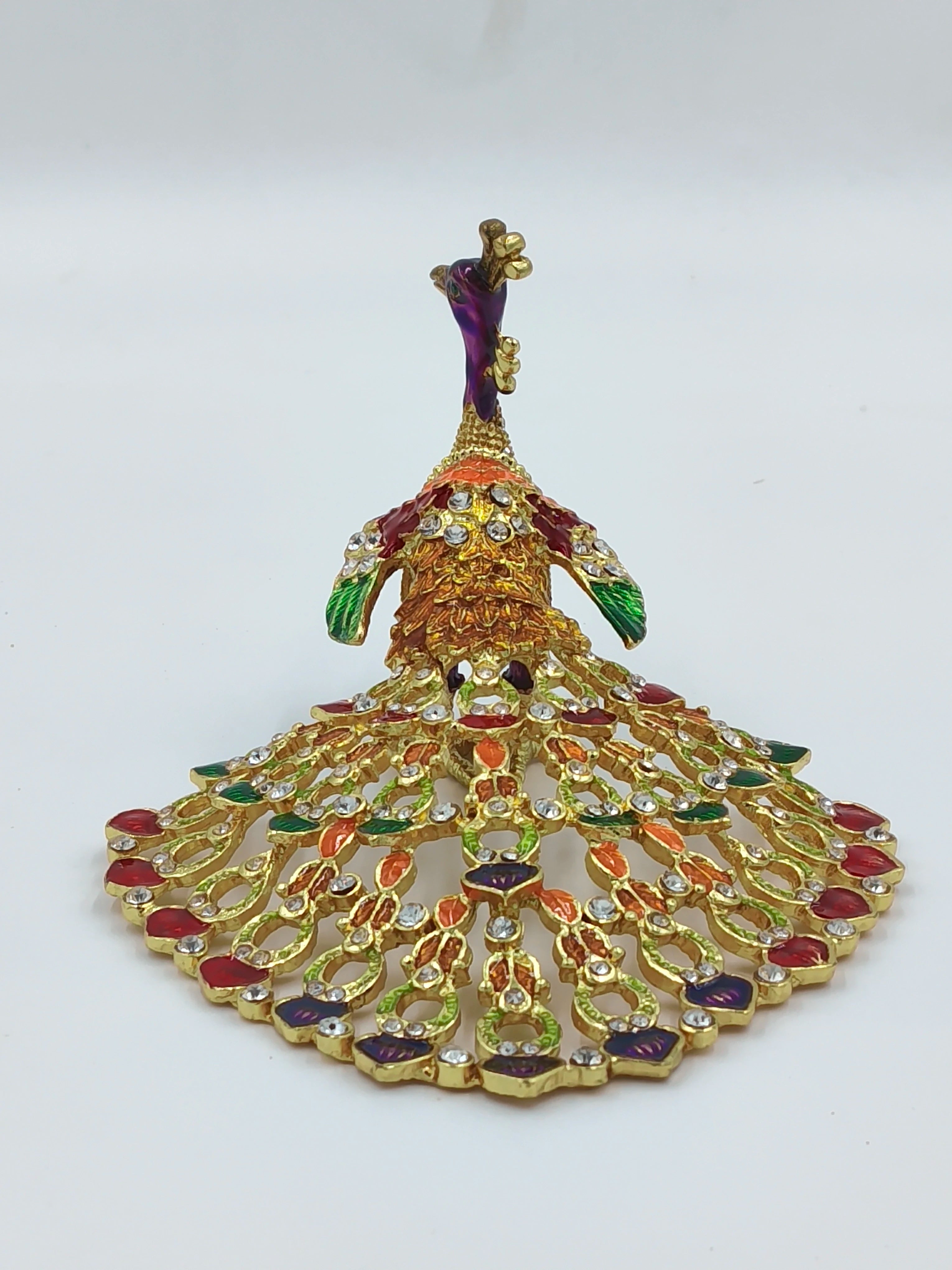 Small brass peacock figurine with copper enamel and gemstone details, front view