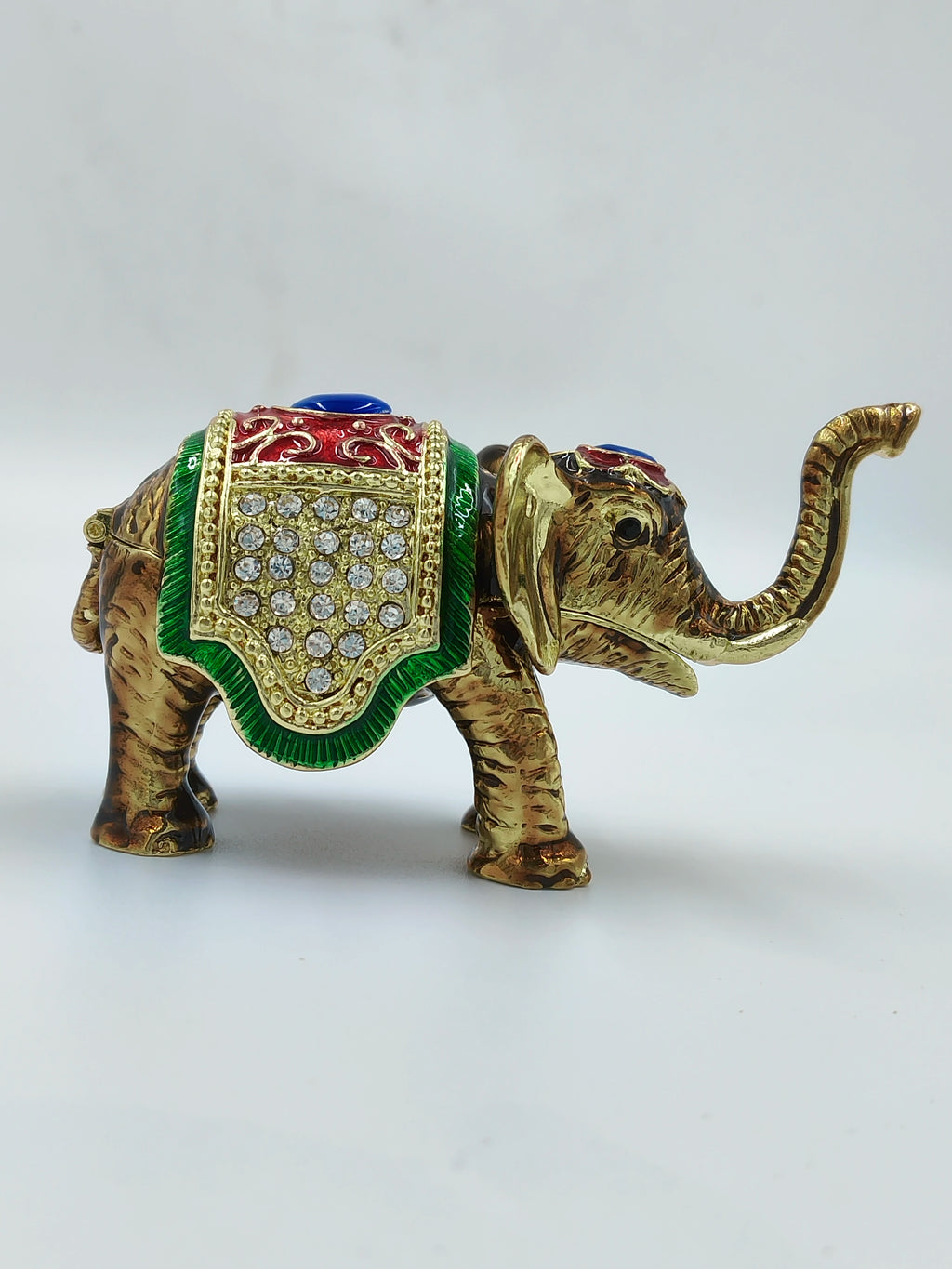 Mini brass elephant figurine with copper enamel and decorative stones side view