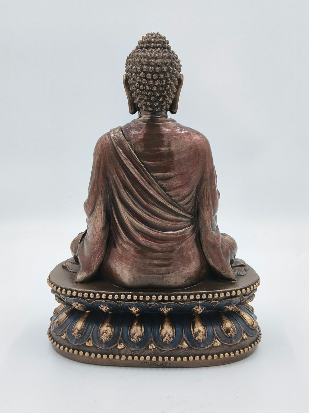 Back view of a large polyresin Buddha statue seated on an ornate base