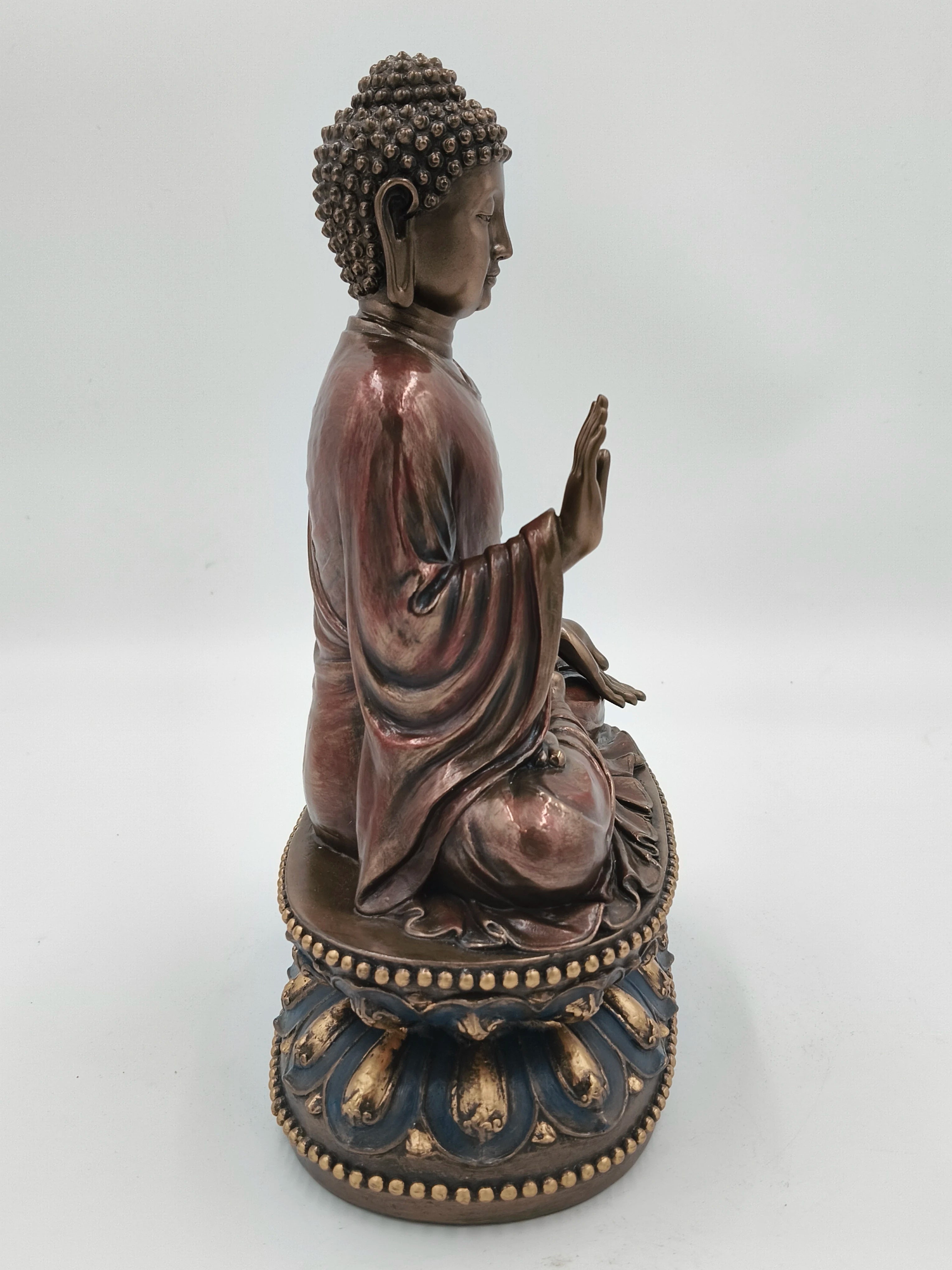 Side view of a large polyresin Buddha statue seated on an ornate lotus pedestal