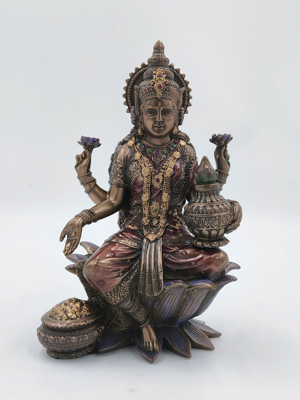 Large polyresin statue of deity Lakshmi seated on lotus with decorative jewelry
