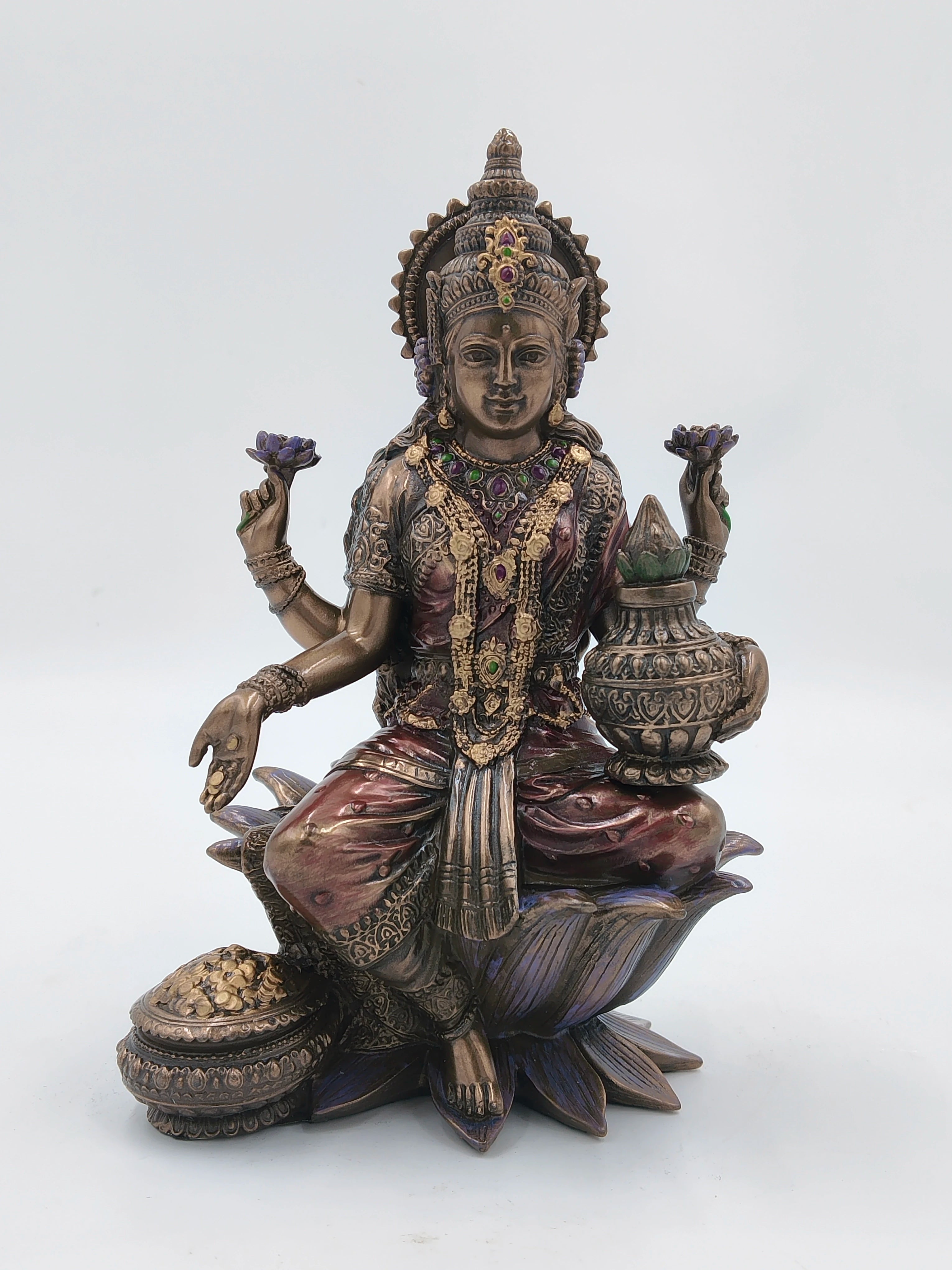 Large polyresin statue of deity Lakshmi seated on lotus with decorative jewelry
