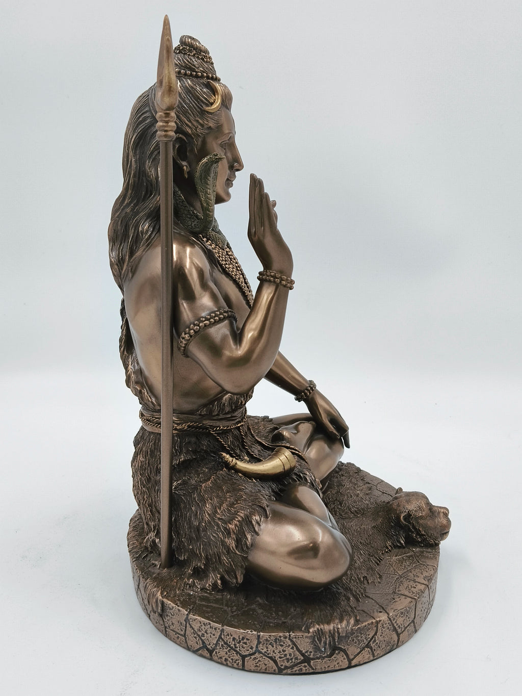 Polyresin statue of Shiva sitting cross-legged with raised hand and trident