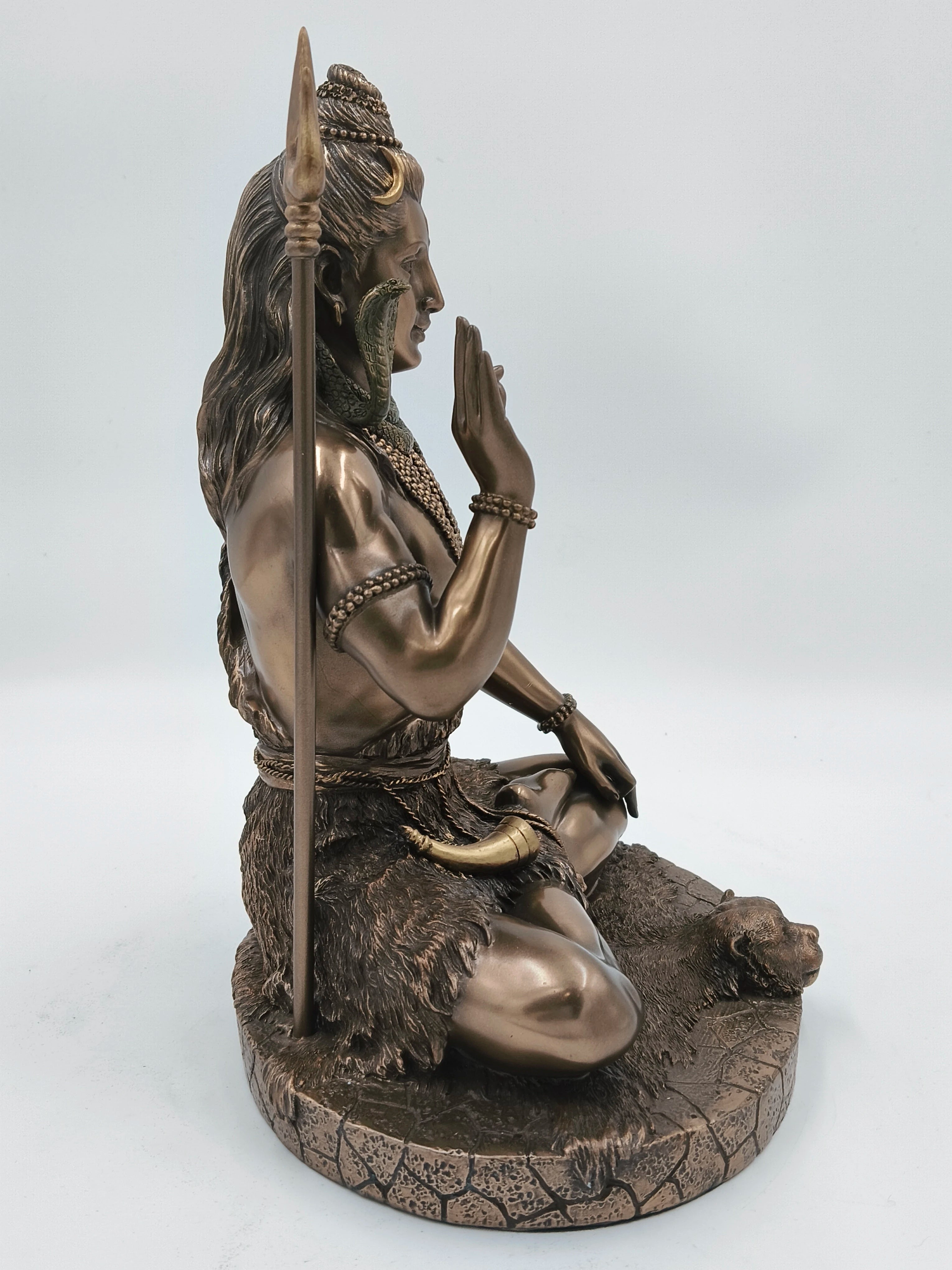 Polyresin statue of Shiva sitting cross-legged with raised hand and trident
