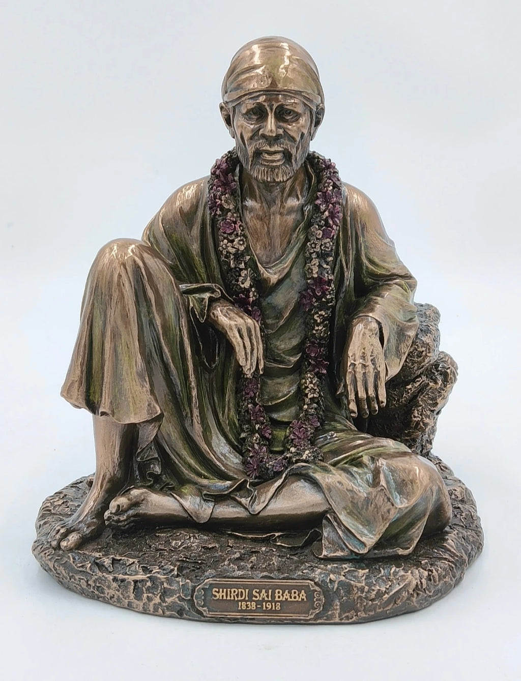 large polyresin statue of Shirdi Sai Baba seated with garland on stone base