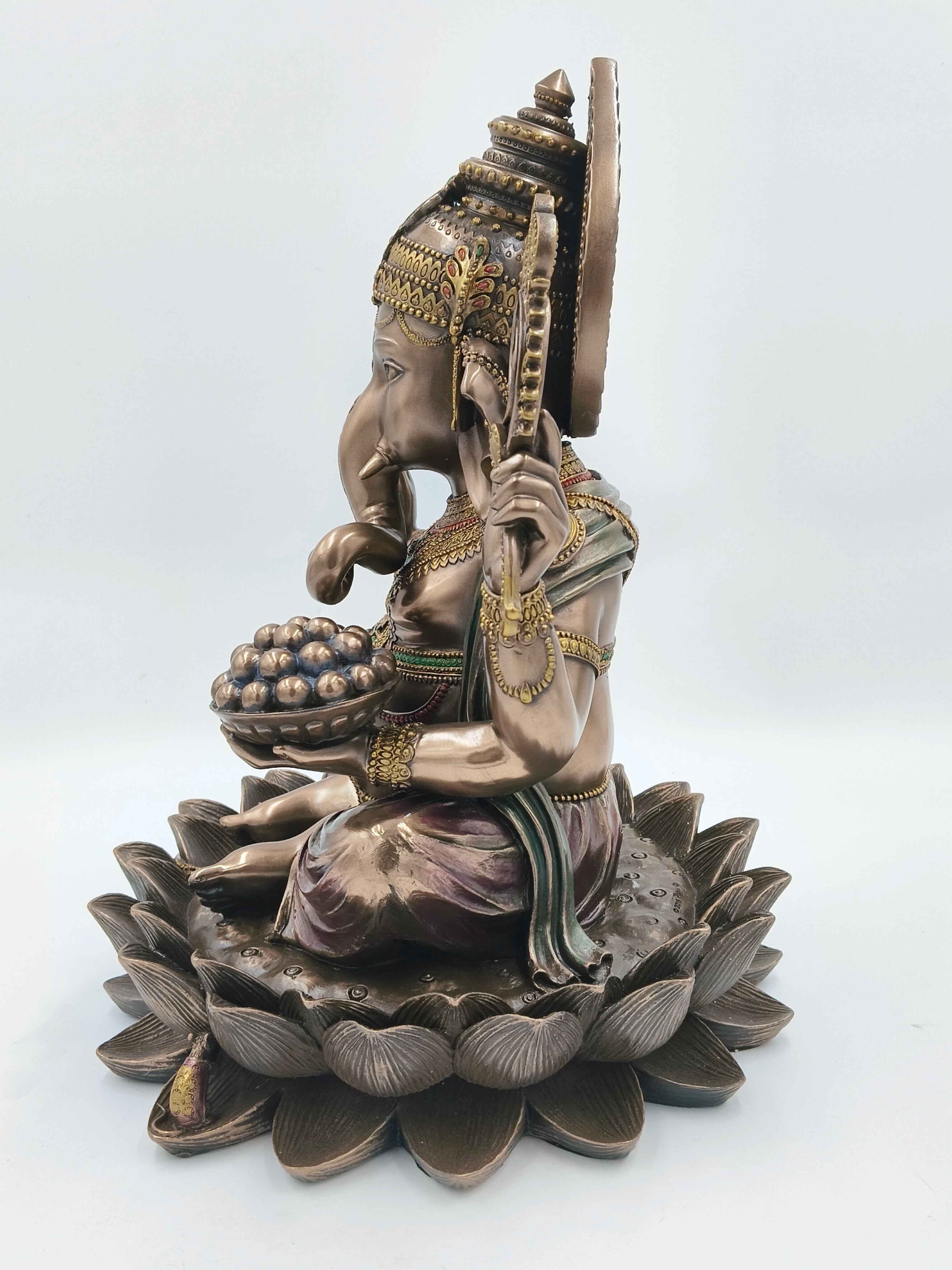 Side view of large polyresin statue of deity Ganesh seated on lotus