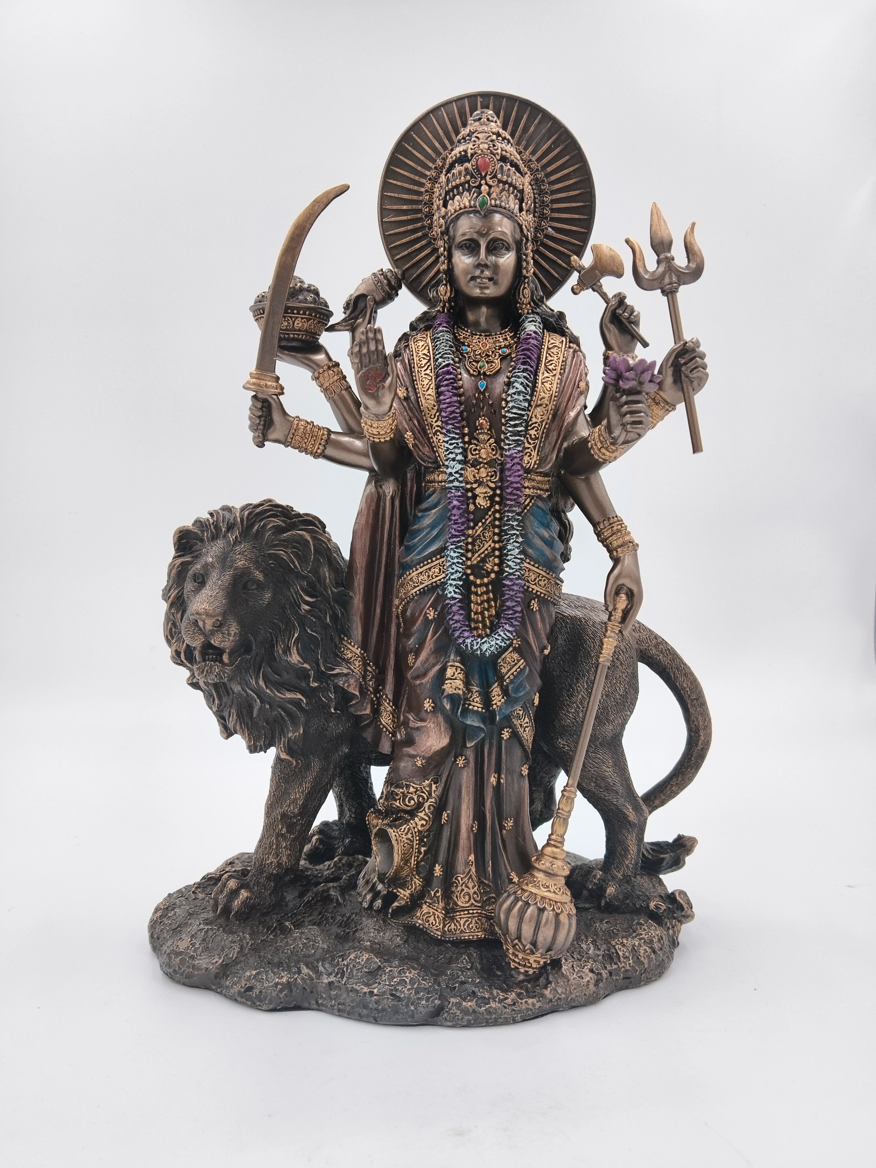 Large polyresin statue of Goddess Durga with multiple arms holding weapons and a lion