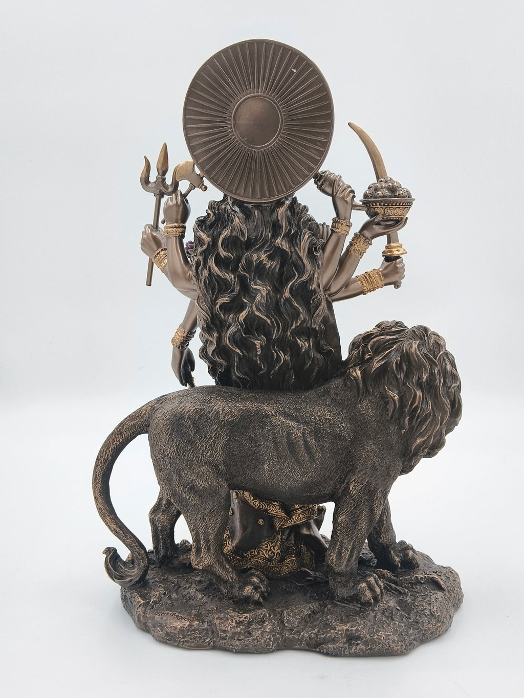Rear view of large polyresin Durga statue with lion and multiple arms holding weapons