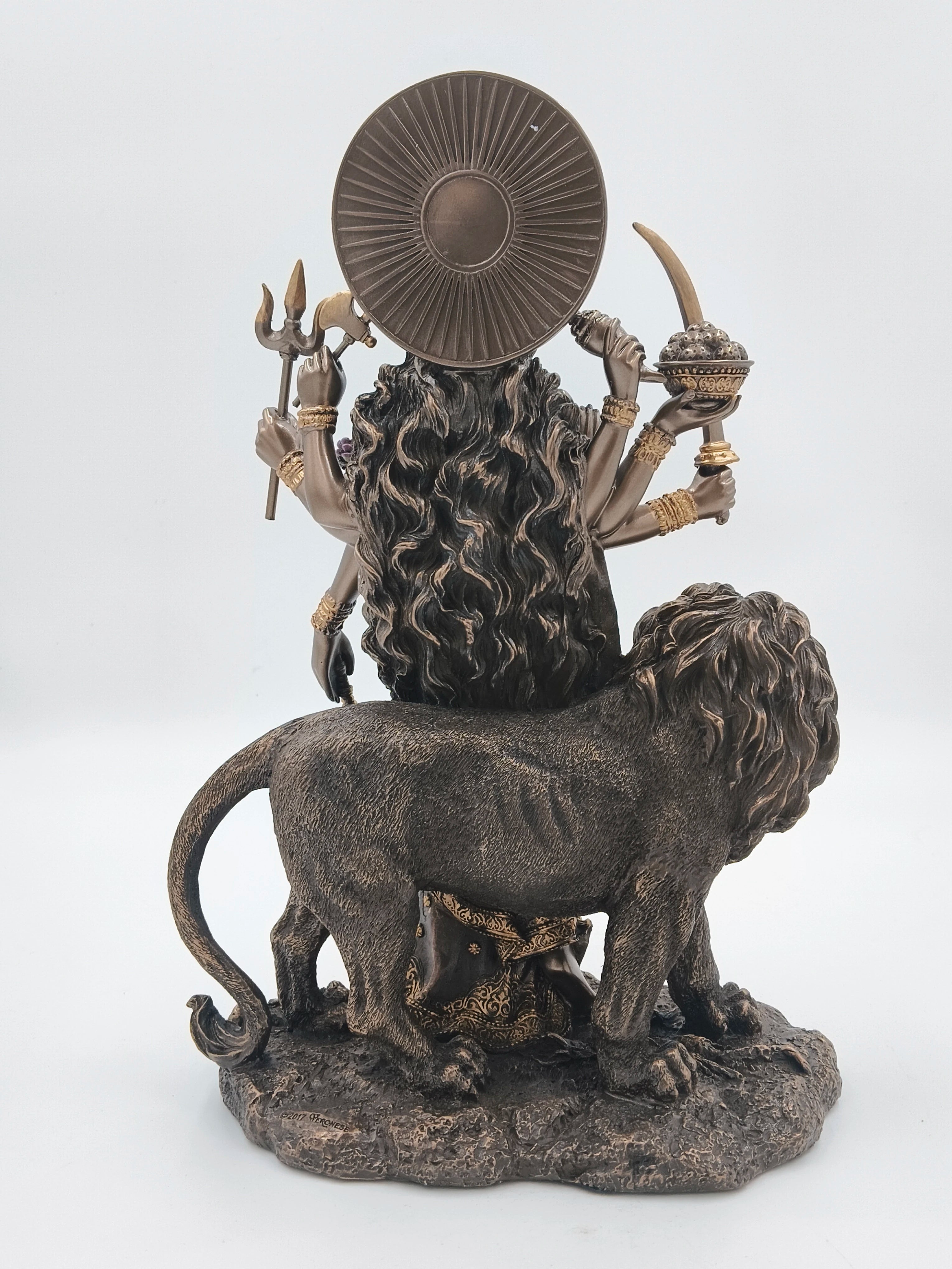 Rear view of large polyresin Durga statue with lion and multiple arms holding weapons