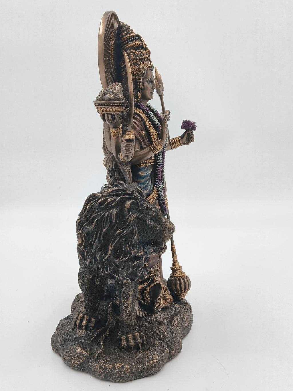 Side view of large polyresin statue of goddess Durga with lion and weapons