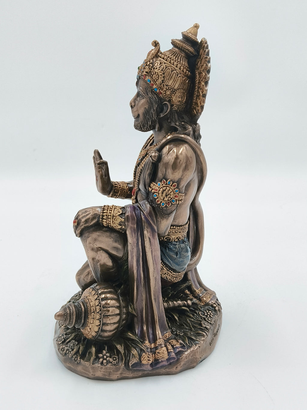 Side view of large polyresin Hanuman statue seated with decorated ornaments