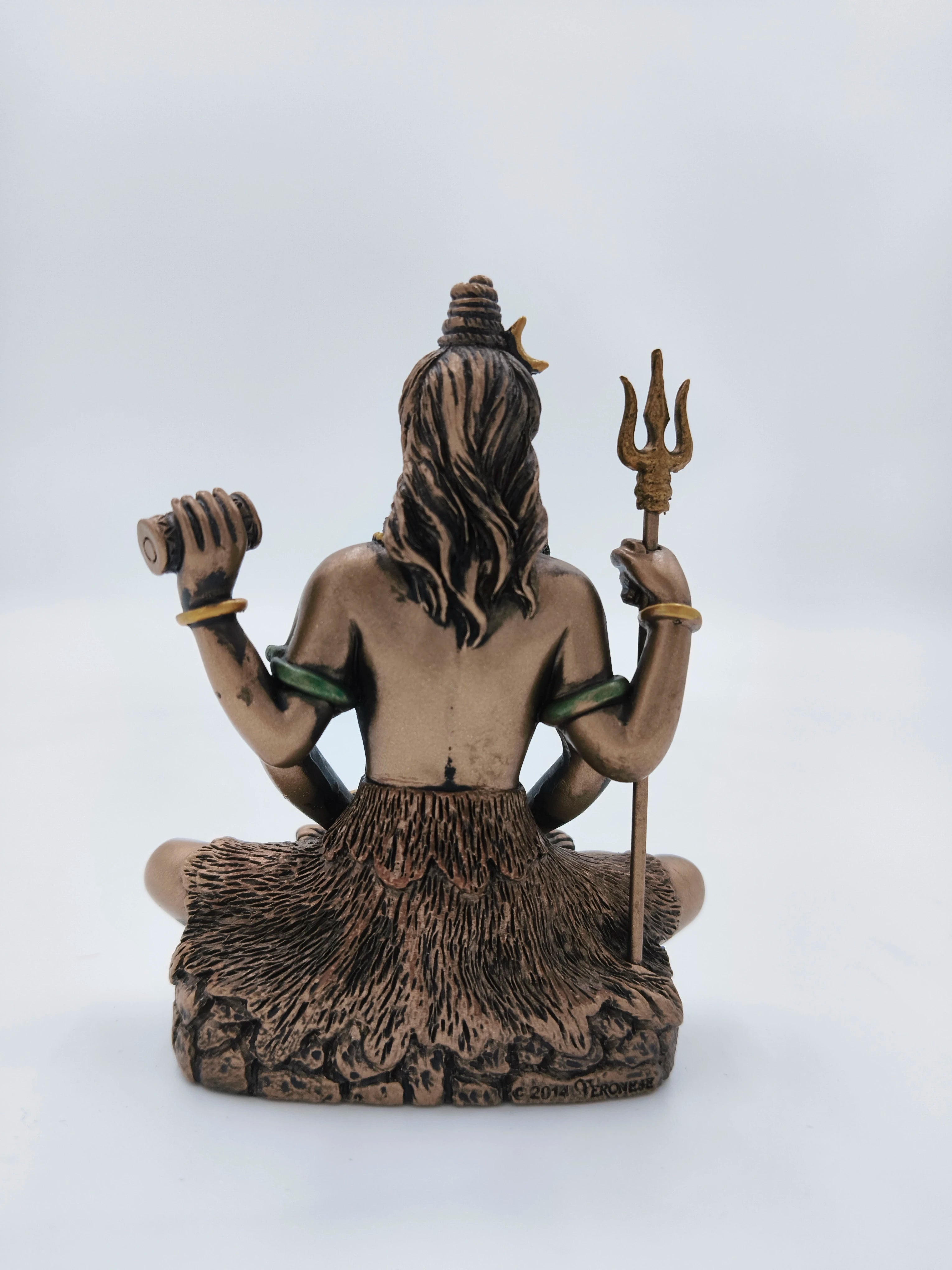 Back view of small polyresin Lord Shiva statue seated holding trident