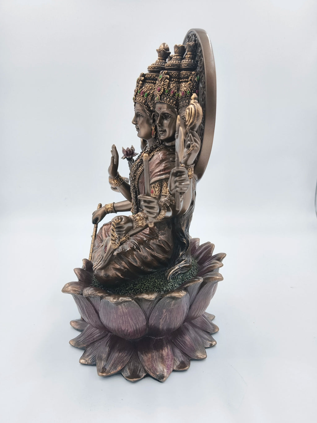 Side view of polyresin statue of Goddess Gayatri seated on lotus with multiple heads and arms