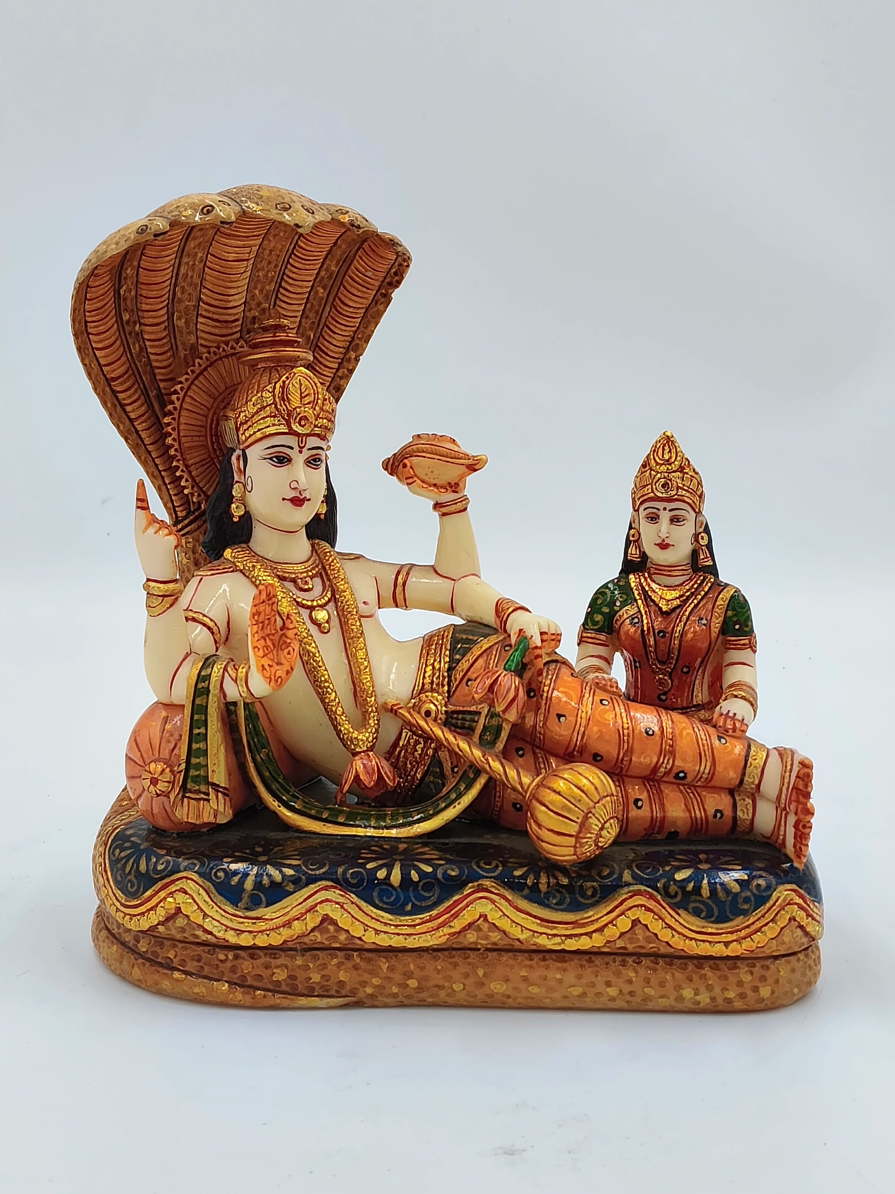 Large polyresin sculpture of Vishnu reclining with Lakshmi seated beside him