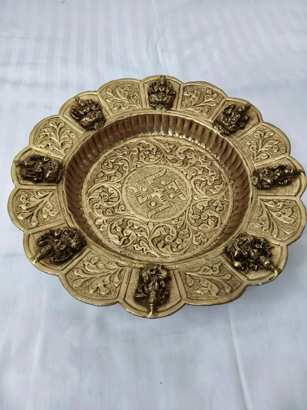 Mini brass decor plate with floral patterns and deity figures around edge